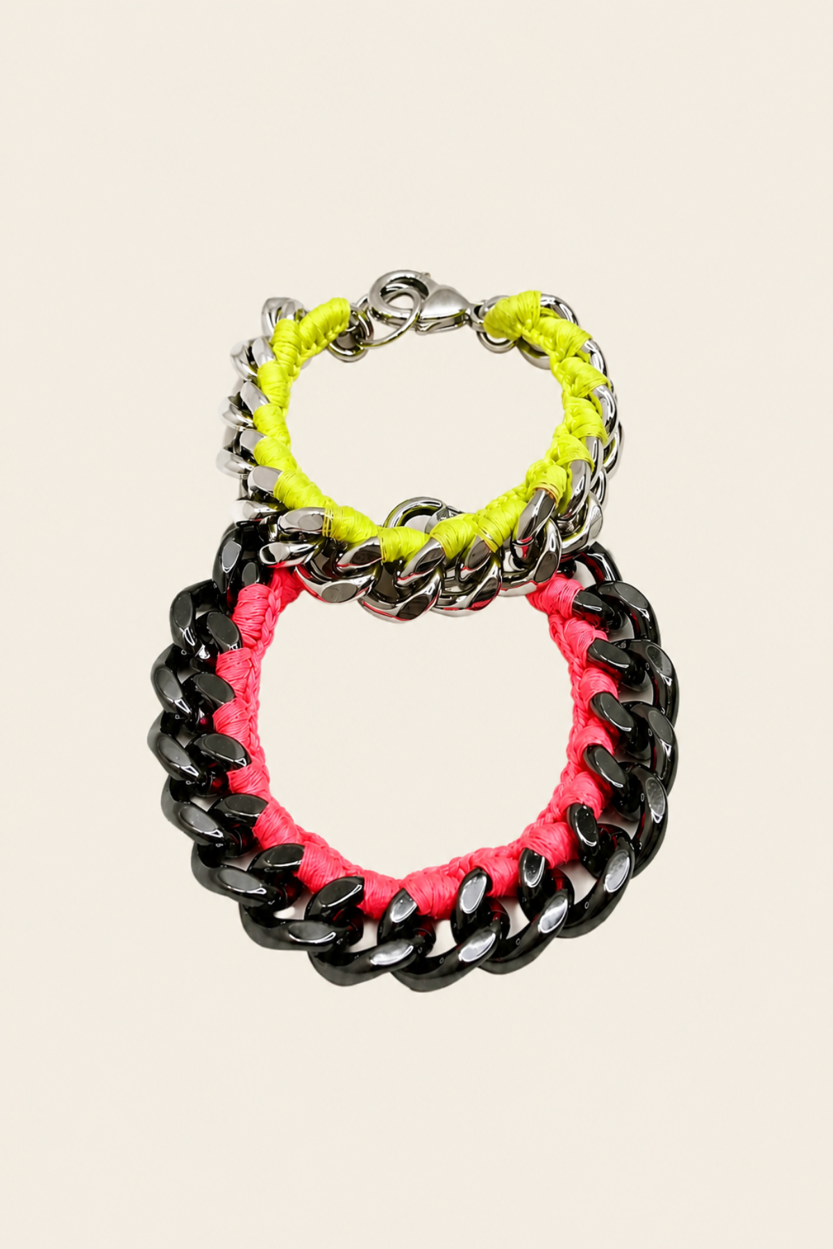 Conjunto de pulseras en neón rosa y amarillo sobre fondo blanco, eslabones grandes y llamativos para un look fresco y original de moda urbana