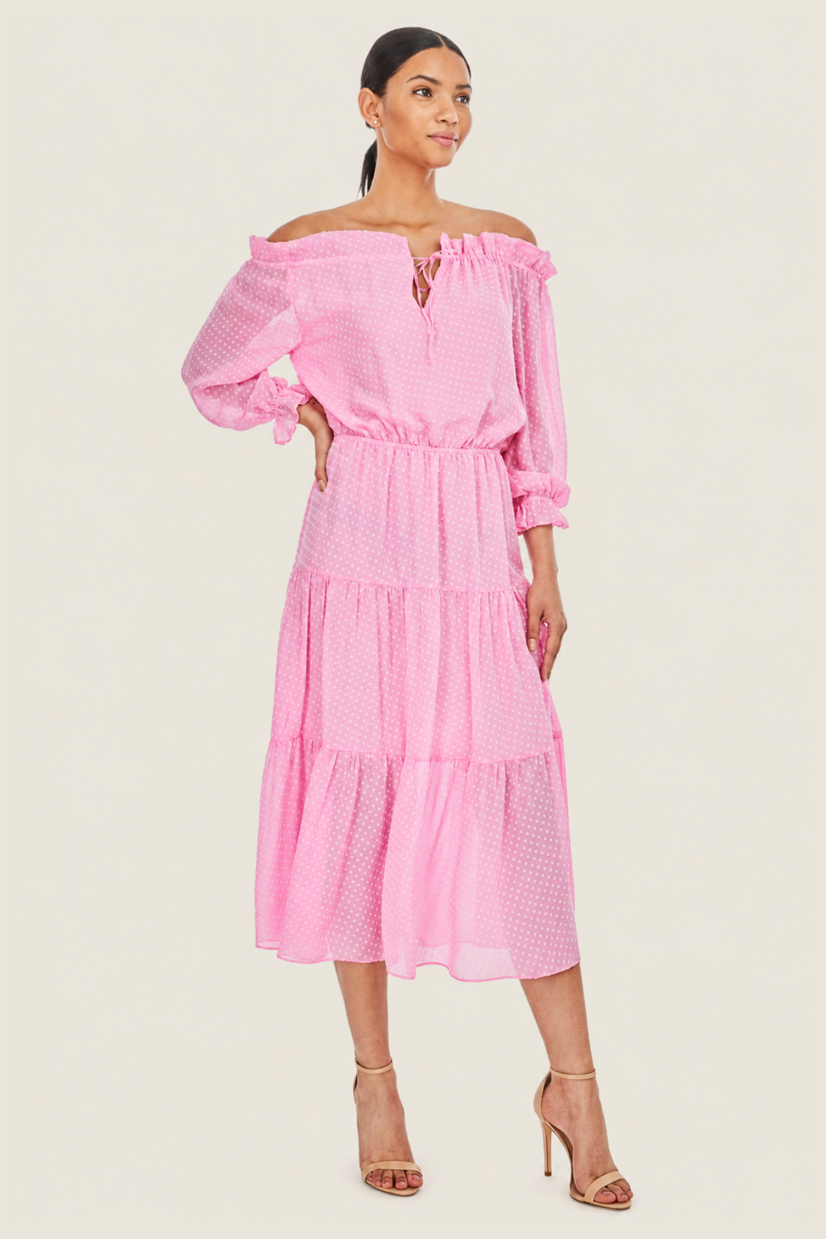 Primer plano del escote en V y hombros descubiertos del vestido Leoni Candy Pink, con cierre de lazo y detalle de plumetti.