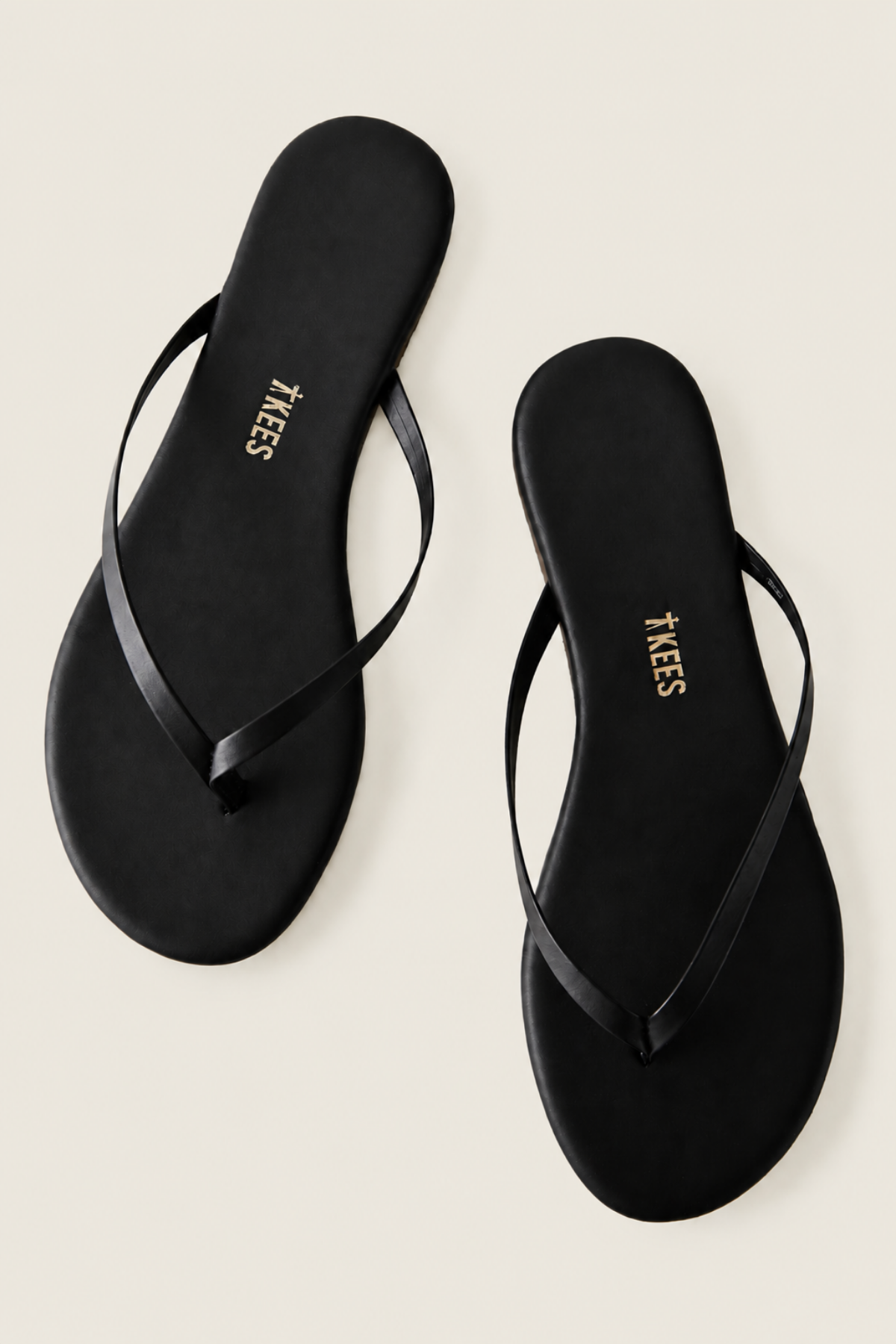 Vista superior de las dos Tkees Black Flip Flops negras, sandalias planas con diseño limpio perfectas para el día a día