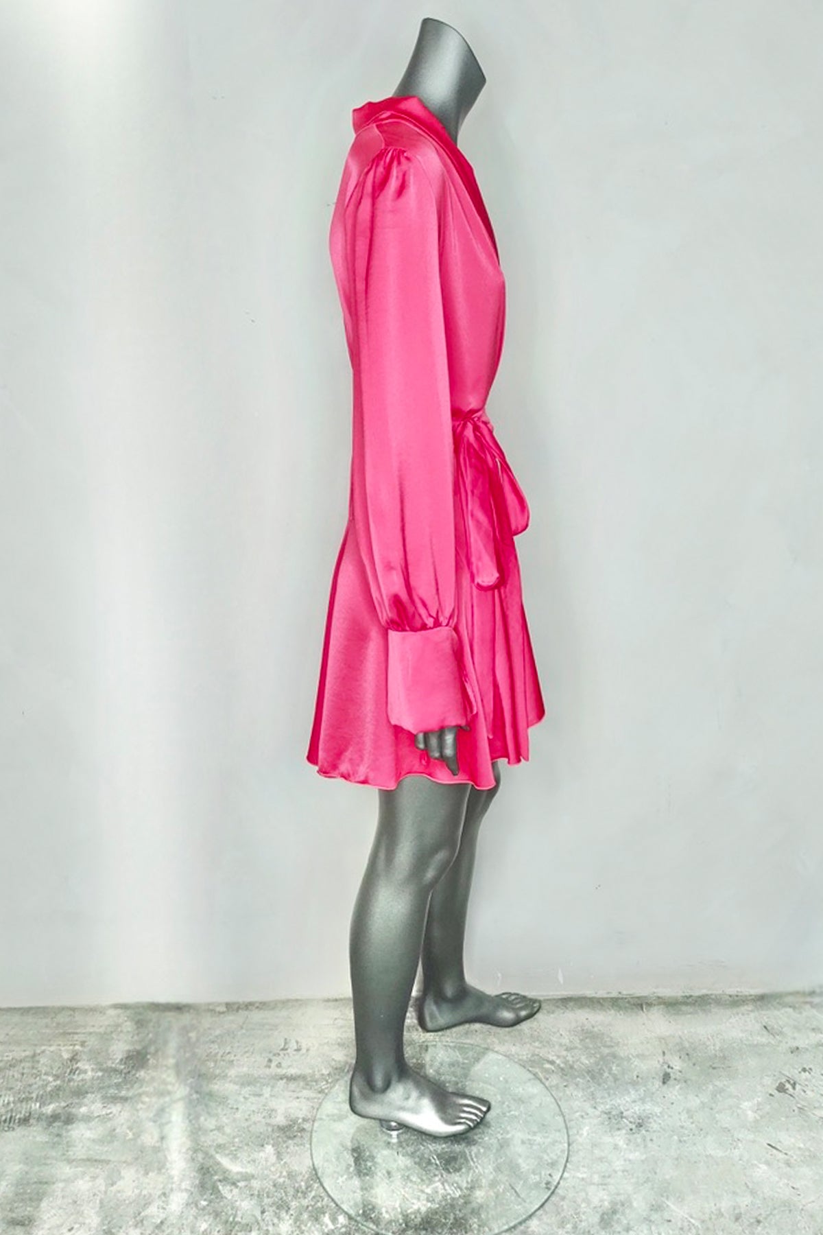 Vestido corto silk wrap fucsia de Margherita Mazzei en maniquí en vista lateral sobre fondo blanco resaltando caída fluida y brillo
