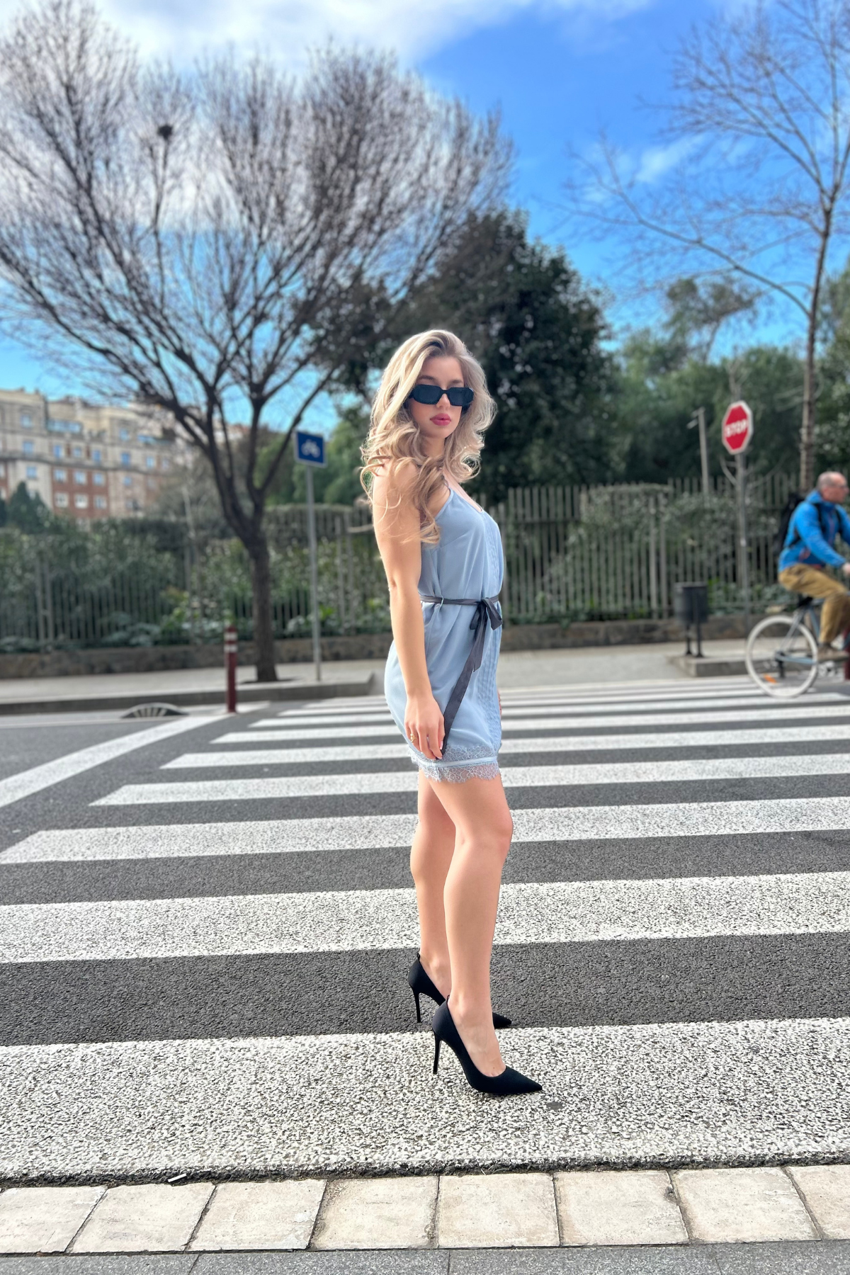 Modelo posando de perfil con el vestido mini Elia de Wink en azul cielo, resaltando su silueta ajustada y elegancia natural