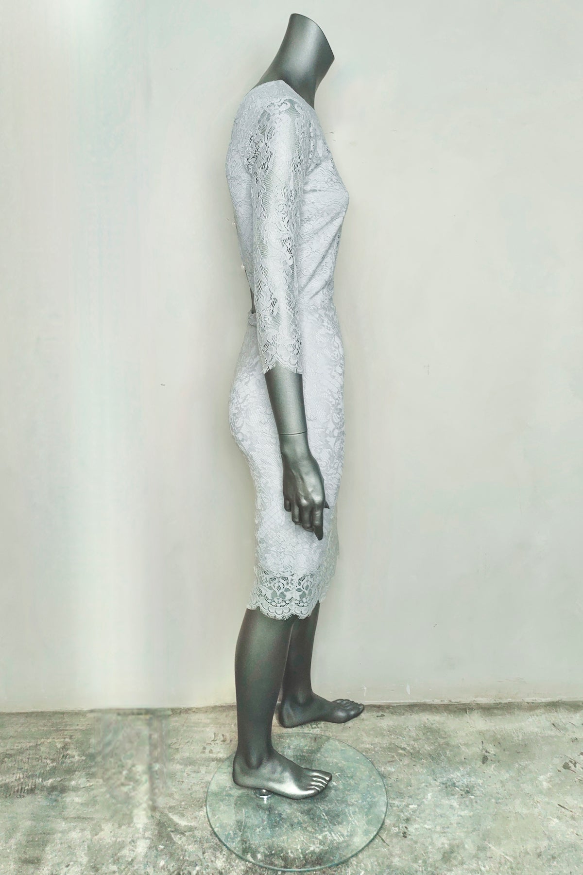 Vista lateral del vestido midi Pot Pourri Lace en maniquí, destacando la cintura ceñida y las mangas largas transparentes con bordados