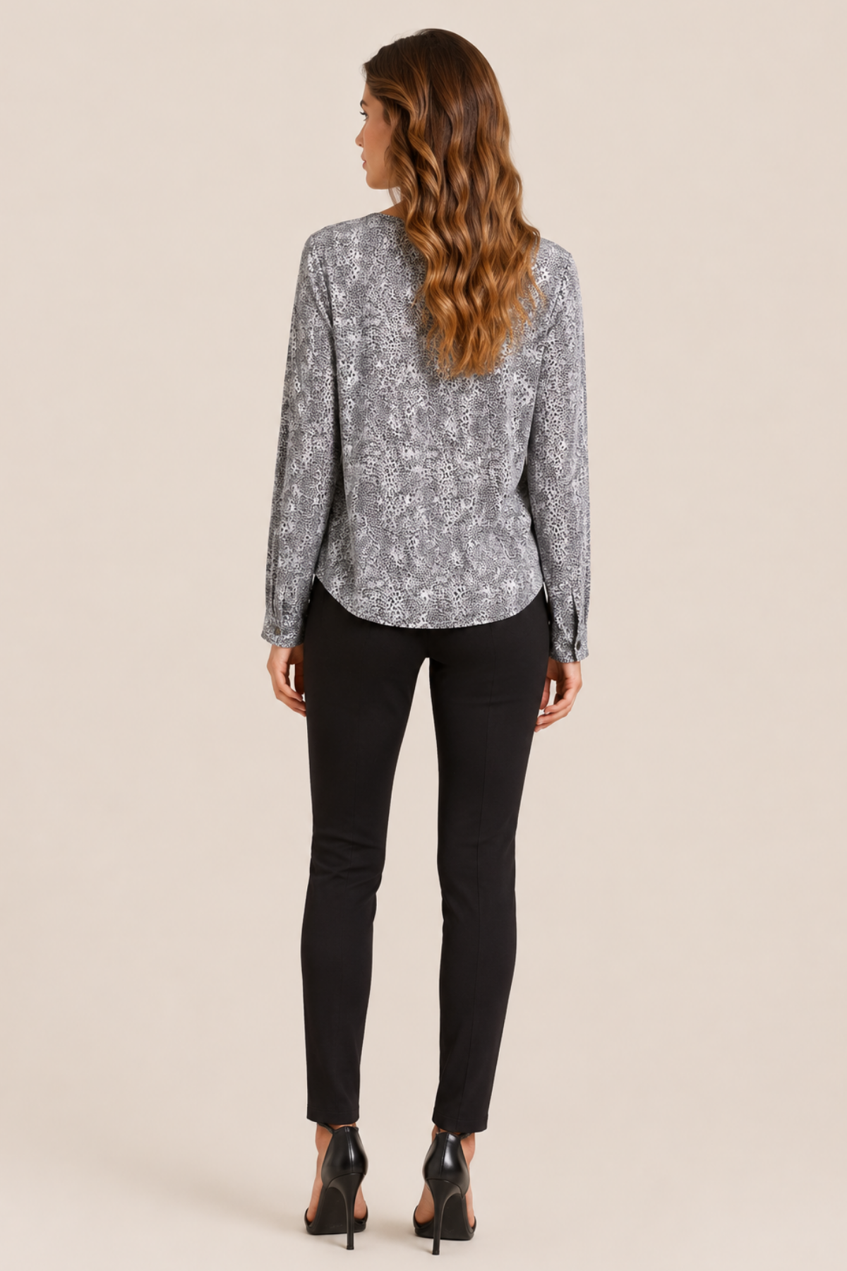 Modelo de espaldas mostrando la blusa Joie Michi cheetah black, costura central y dobladillo ligeramente redondeado para acabado elegante