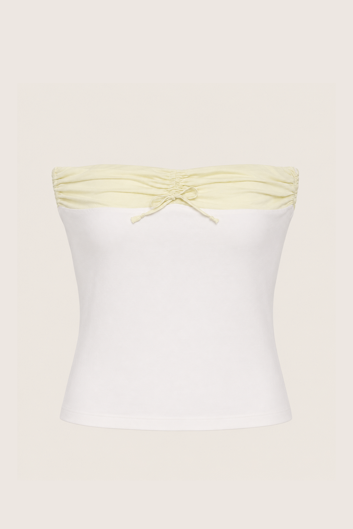 Top bandeau bicolor blanco y verde menta en empaque transparente mostrando corte ajustado elegante para looks veraniegos