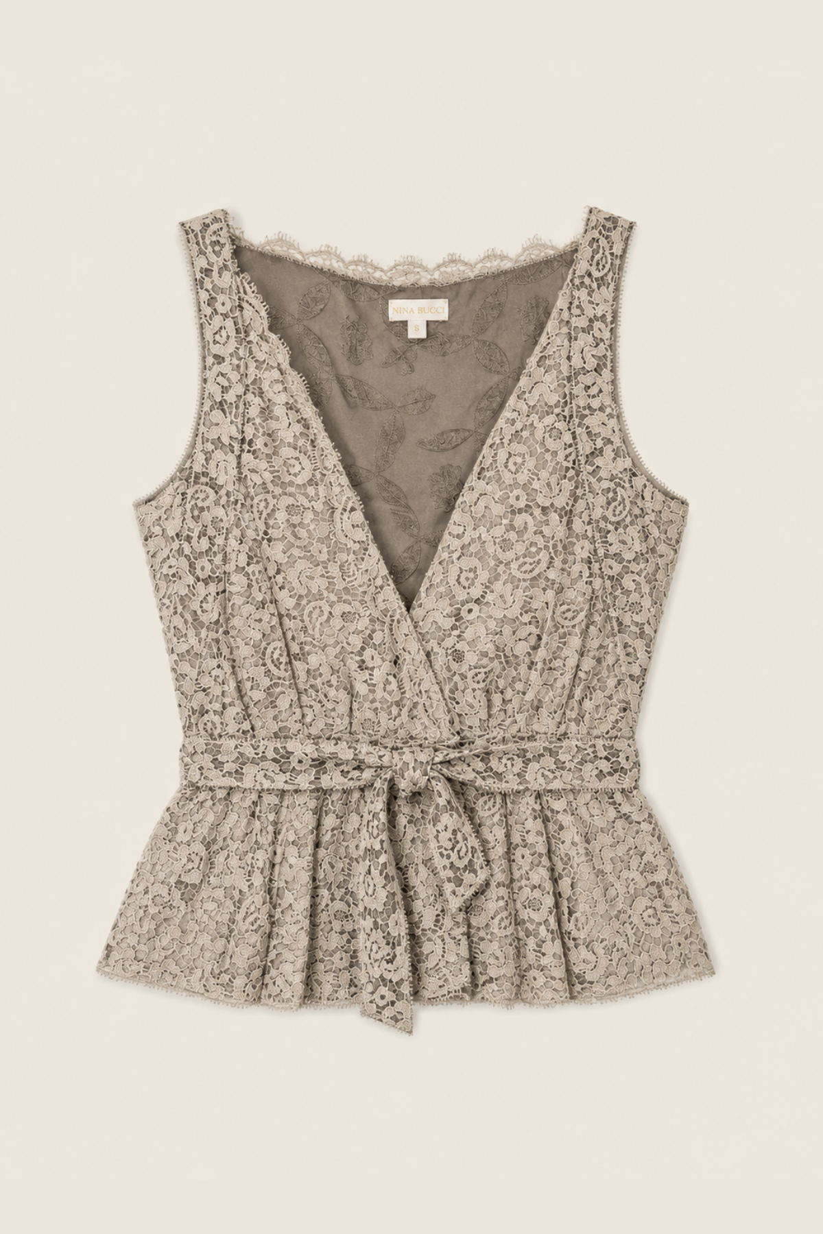 Top gris de encaje Nina Ricci sobre fondo blanco, mostrando el delicado diseño floral y la textura sofisticada para un look elegante y moderno