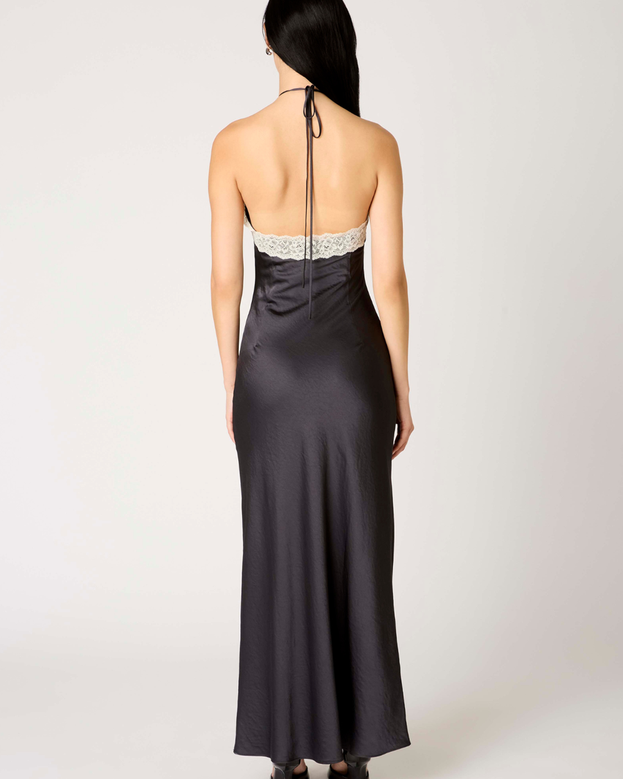 Vista trasera del vestido largo Vesper en color soot black, mostrando la caída fluida del tejido y la silueta elegante de la espalda