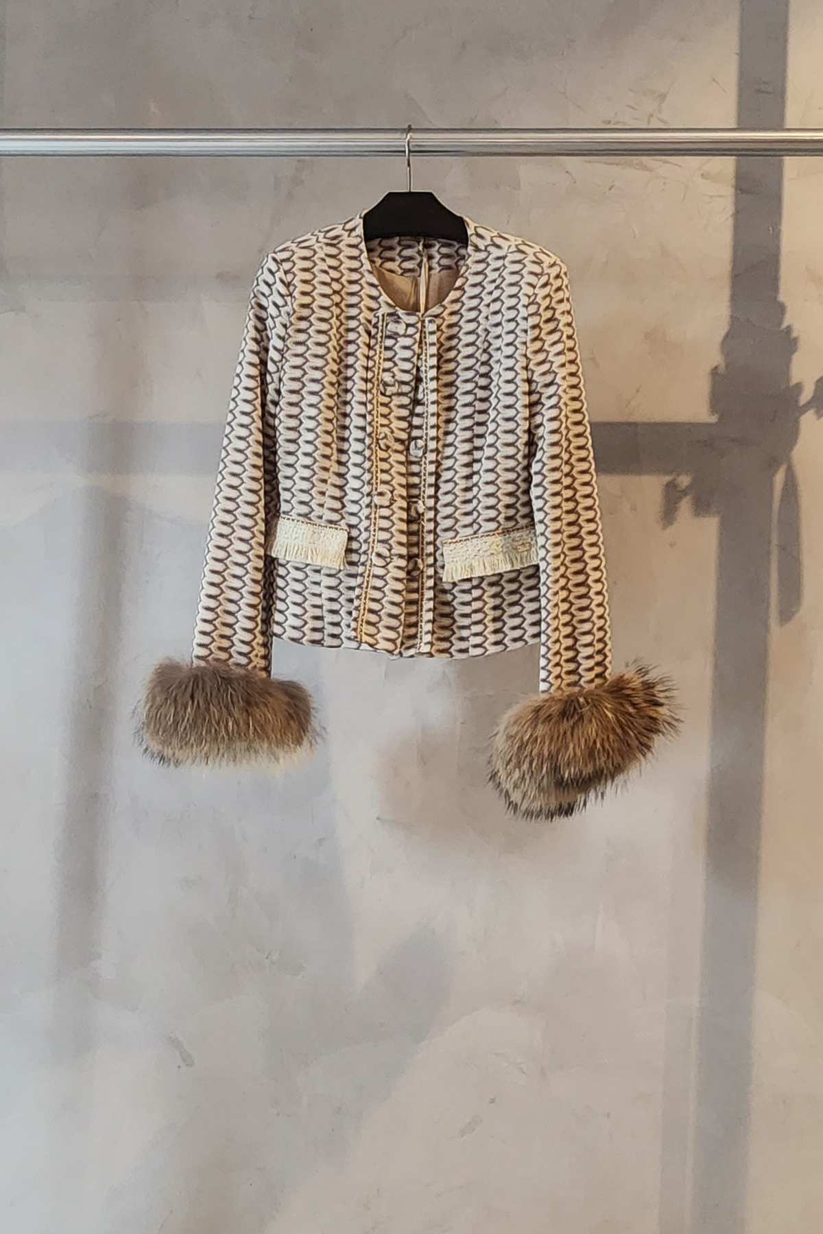 Chaqueta Rachel Pho Firenze con estampado charme y puños de piel sintética colgada en percha mostrando corte entallado elegante