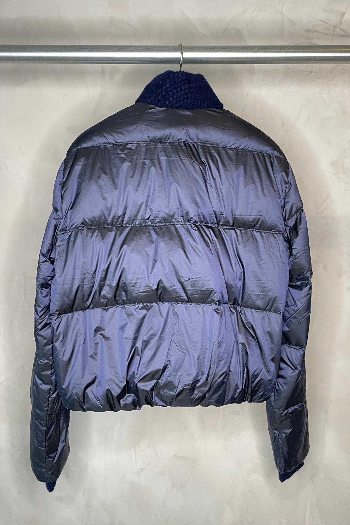 Chaqueta Cortland Park The SG Down en navy/silver vista trasera colgada en percha con diseño acolchado y acabado metalizado elegante