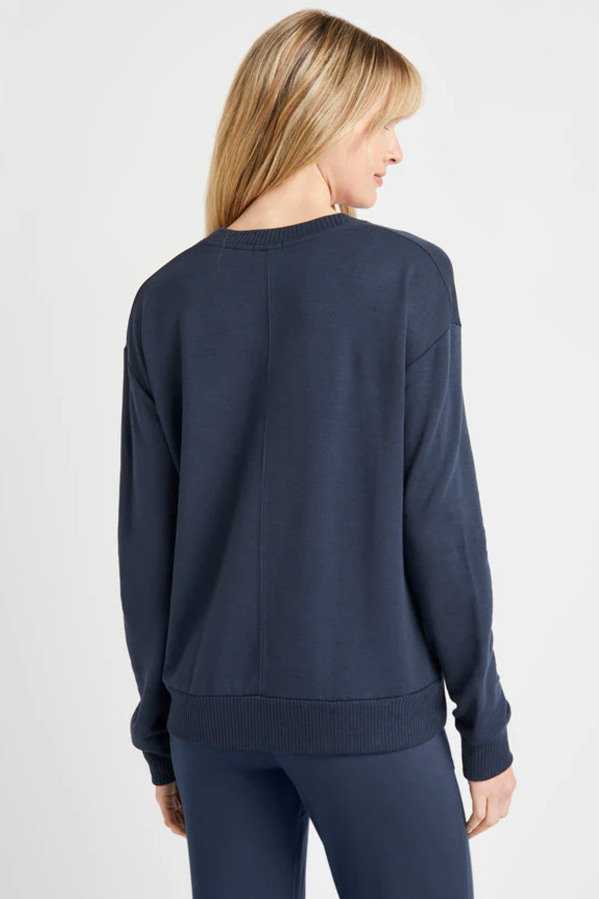 Modelo de espaldas luciendo el jersey Splendid Supersoft en Navy, mostrando la caída natural y el tejido suave ideal para looks casuales