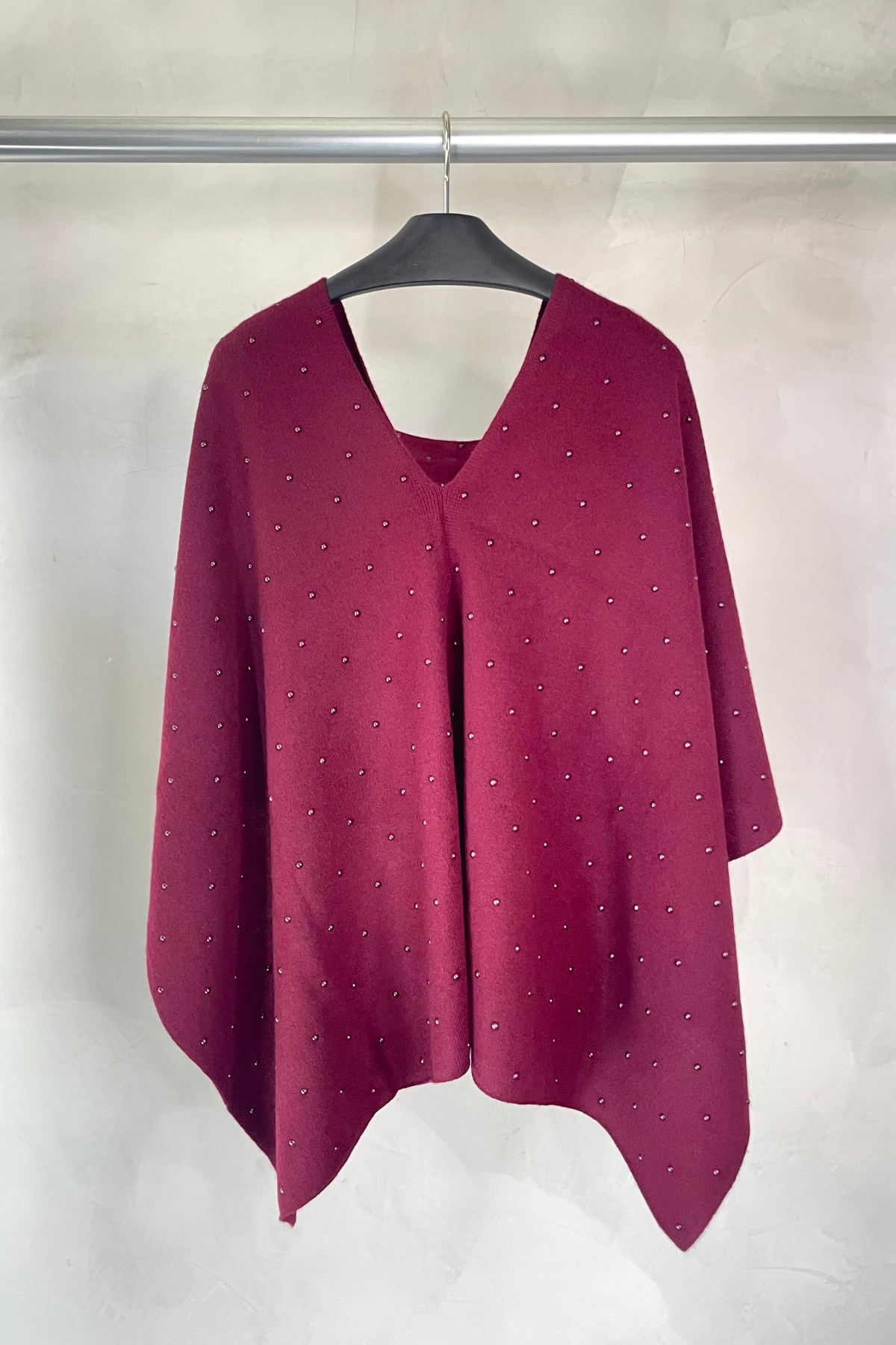 Vista trasera del poncho color vino In Cashmere con caída suave y diseño elegante ideal para looks relajados y con estilo