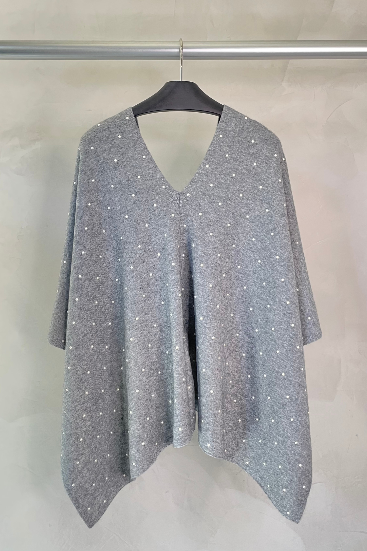 Parte trasera del poncho Heather Grey mostrando su diseño amplio, suave caída y terminaciones cuidadosamente elaboradas