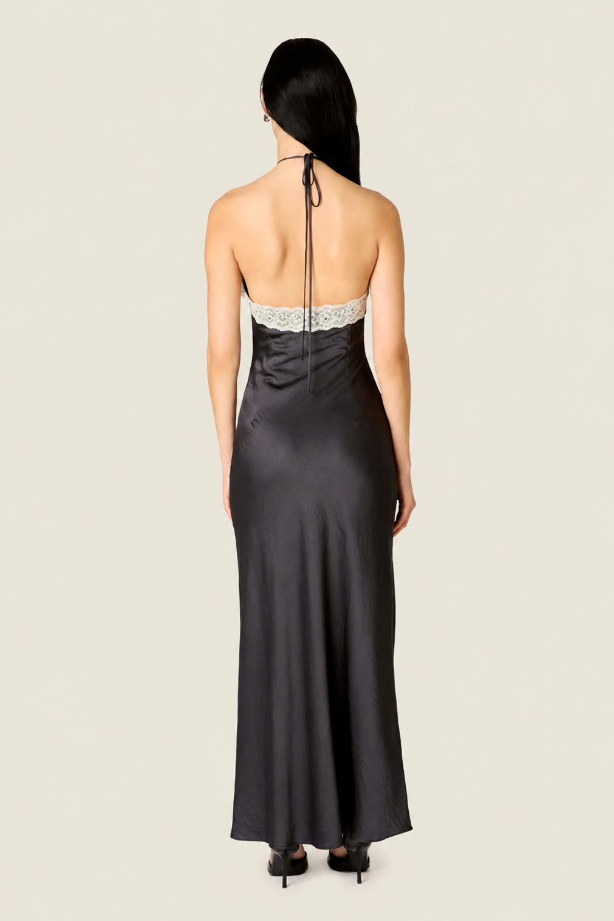 Vista trasera del vestido largo Vesper en color soot black, mostrando la caída fluida del tejido y la silueta elegante de la espalda