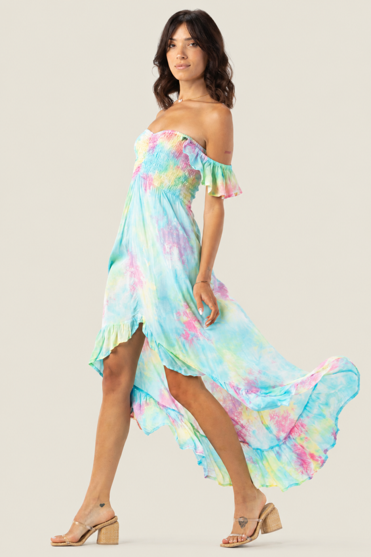 Modelo posando en vista lateral con vestido maxi Tiare Hawaii Brooklyn en colores rosa, aqua y amarillo con diseño vaporoso