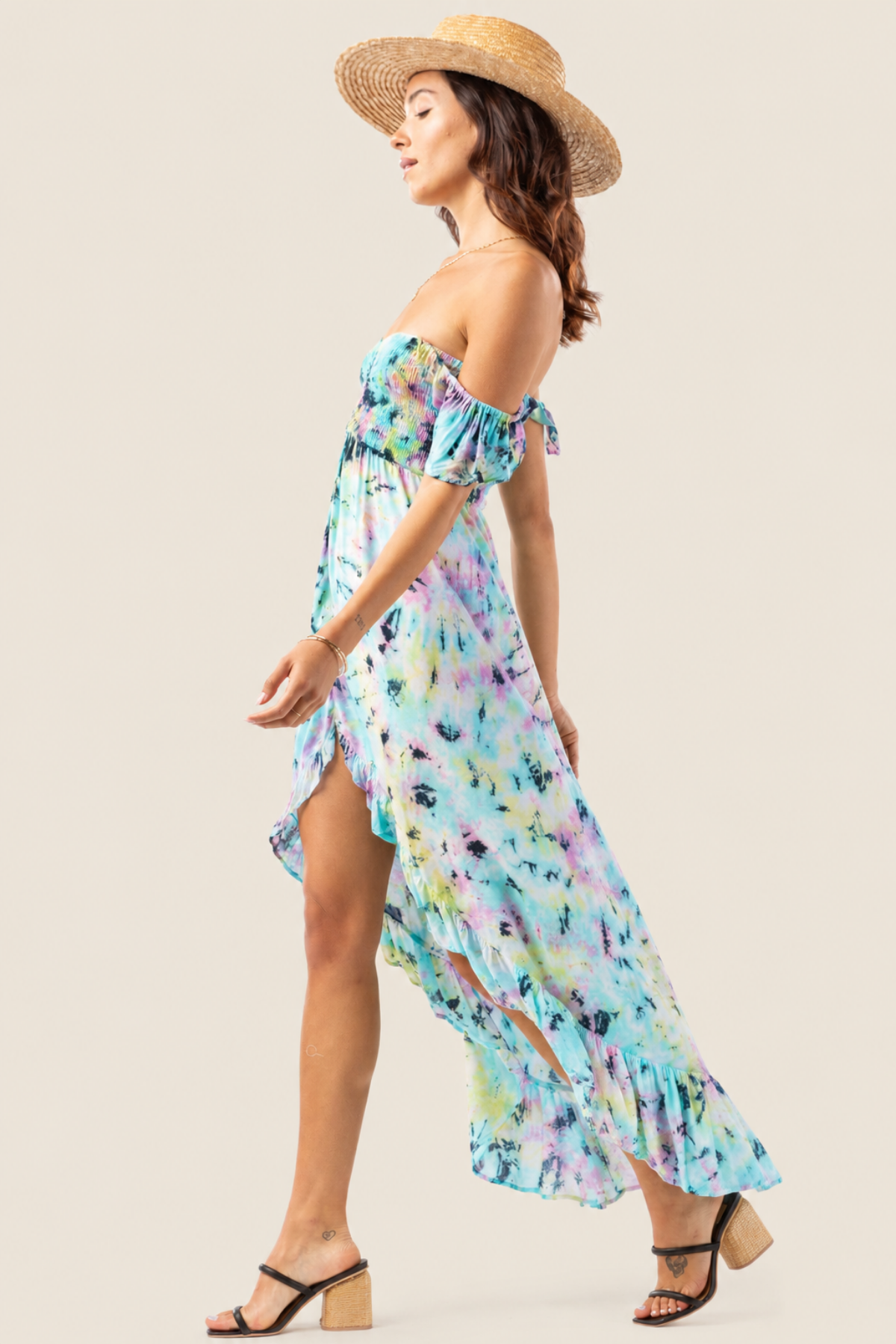 Modelo posando en vista lateral con vestido maxi Tiare Hawaii Brooklyn en degradado rosa, amarillo y azul con estilo bohemio