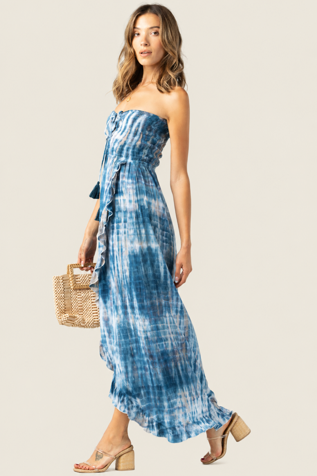 Vista lateral del Flynn maxi en estampado leo tie dye navy‑stone‑white, mostrando silueta cruzada y movimiento en falda