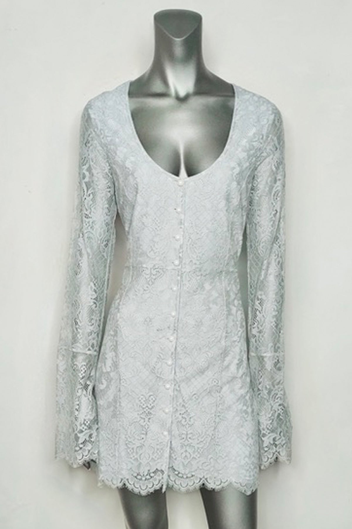 Primer plano del vestido For Love & Lemons corto manga larga en maniquí, resaltando la confección del encaje y detalles en el busto