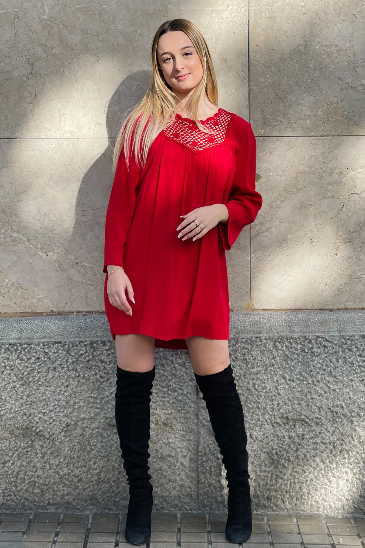 Modelo posando frontalmente con vestido corto Eternal Sunshine en lipstick red con detalles de crochet en mangas y cuello, sobre fondo neutro