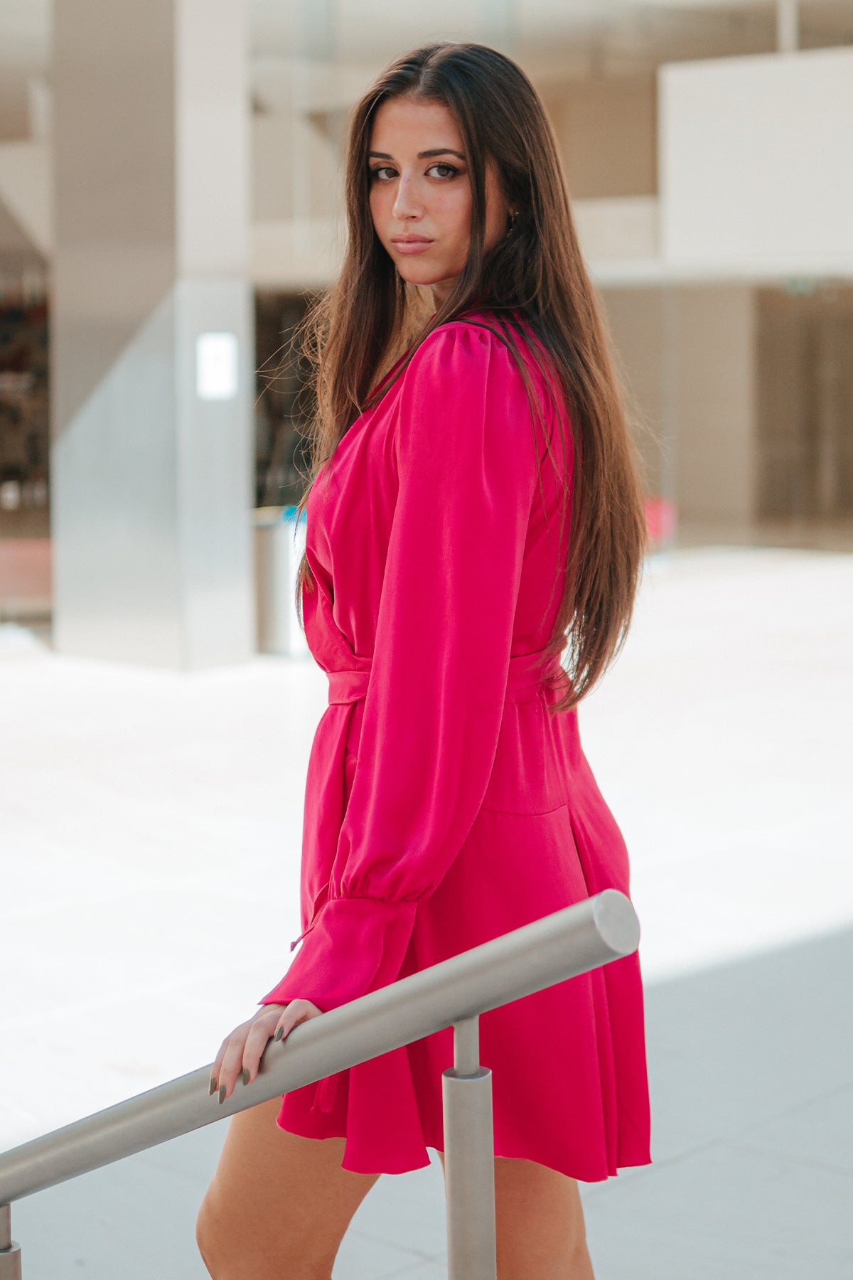 Vista lateral del vestido wrap fucsia de Margherita Mazzei en modelo, destacando elegante silueta femenina y caída refinada