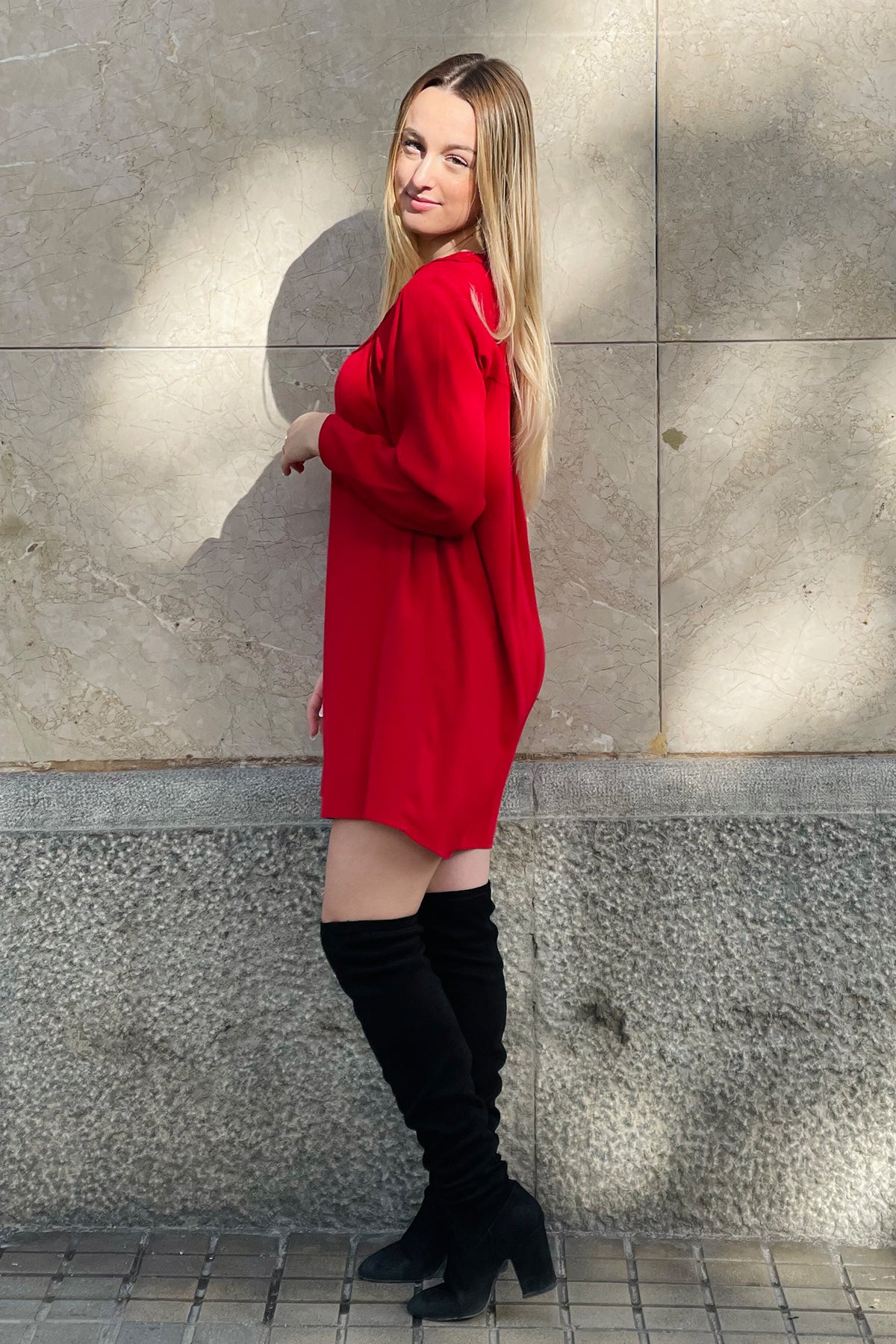 Vista lateral del vestido corto Rosemary en rojo, mostrando mangas onduladas y caída fluida en tejido crepé, sobre fondo neutro