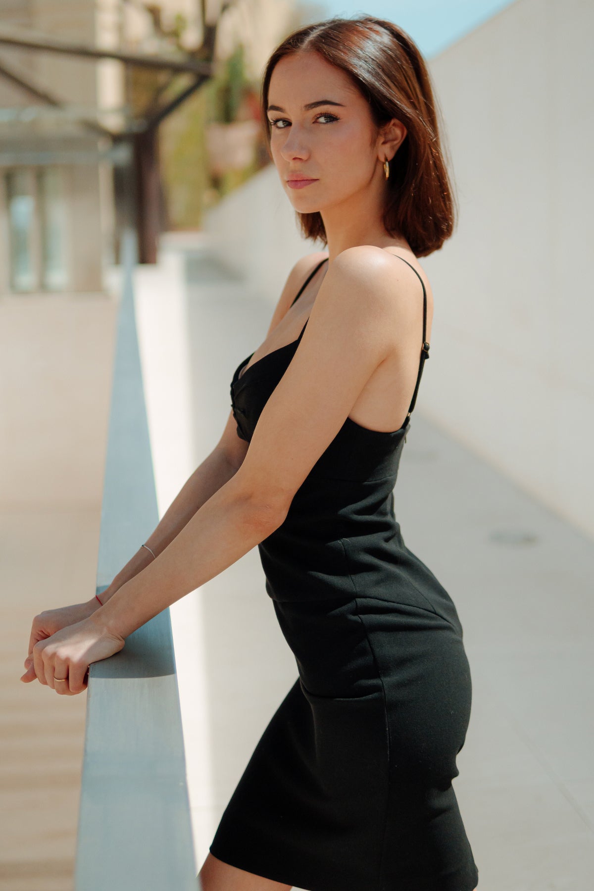 Modelo posando con el vestido corto Black Halo en negro, resaltando su corte clásico y estilo sofisticado, sobre fondo neutro