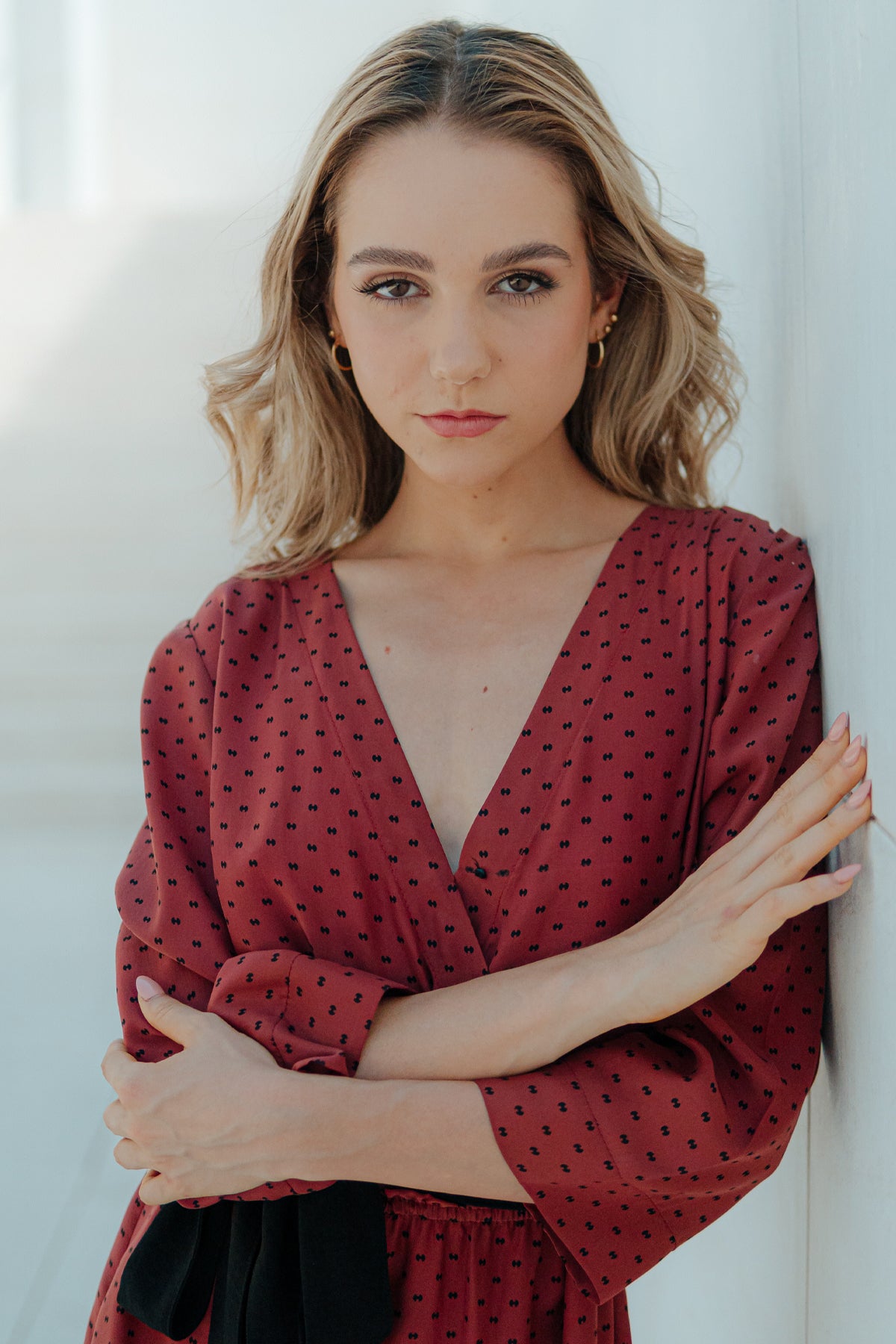 Primer plano de la modelo con vestido Eskell Eva en rust, resaltando escote, textura de seda y estampado minimalista sobre fondo neutro