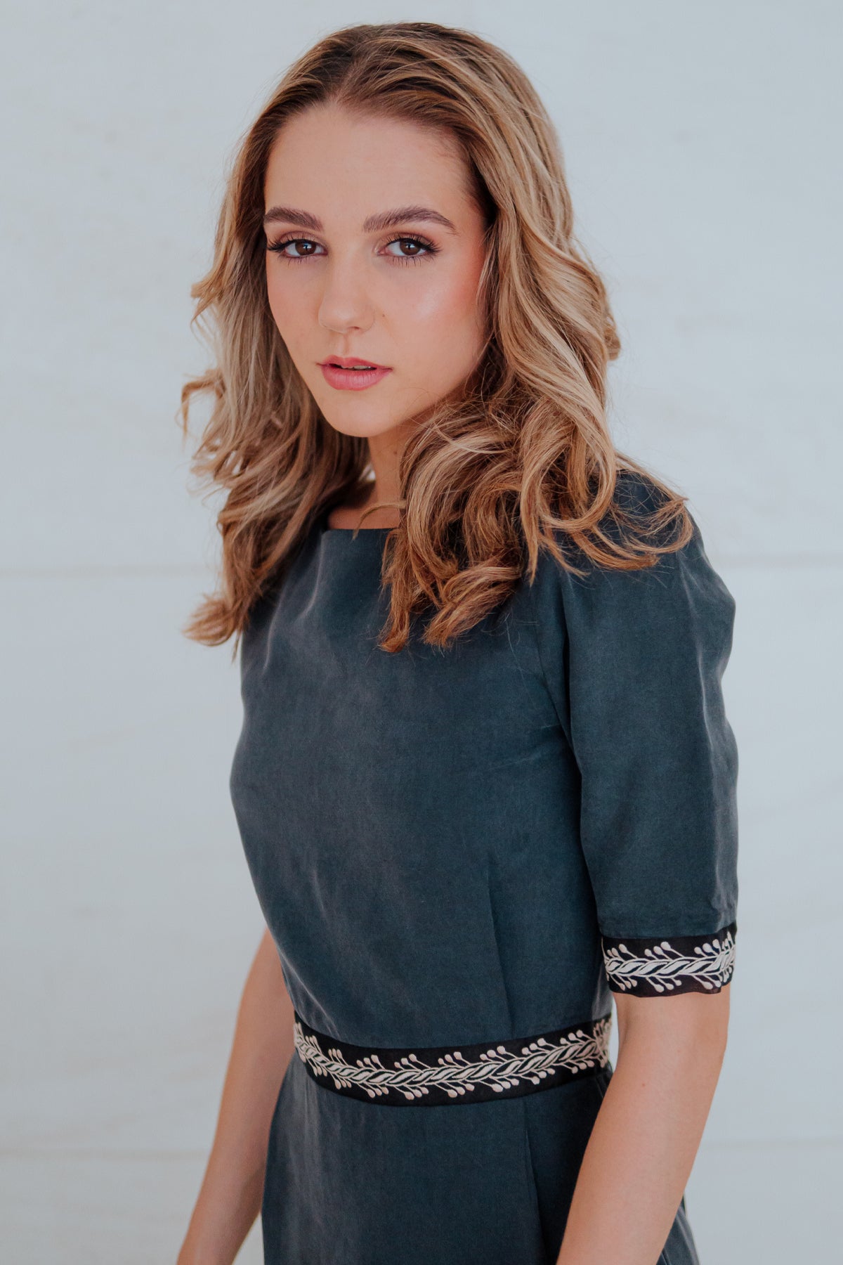 Modelo con vestido midi Mike de Lyell en gris en plano frontal sobre fondo blanco que resalta el diseño y ajuste del vestido