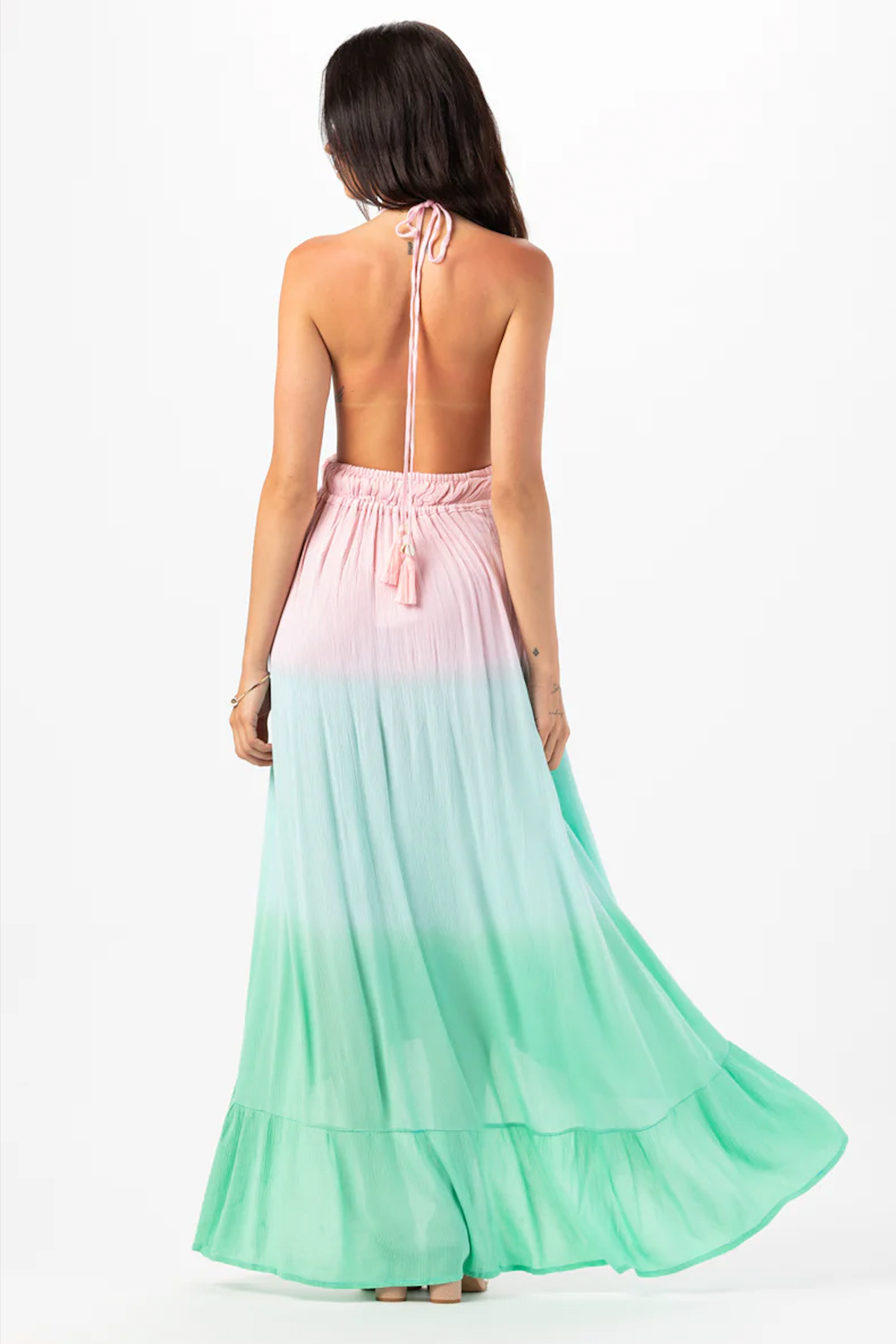 Modelo mostrando la vista trasera del vestido maxi Bianca en blanco, con caída fluida y tirantes finos para estilo elegante