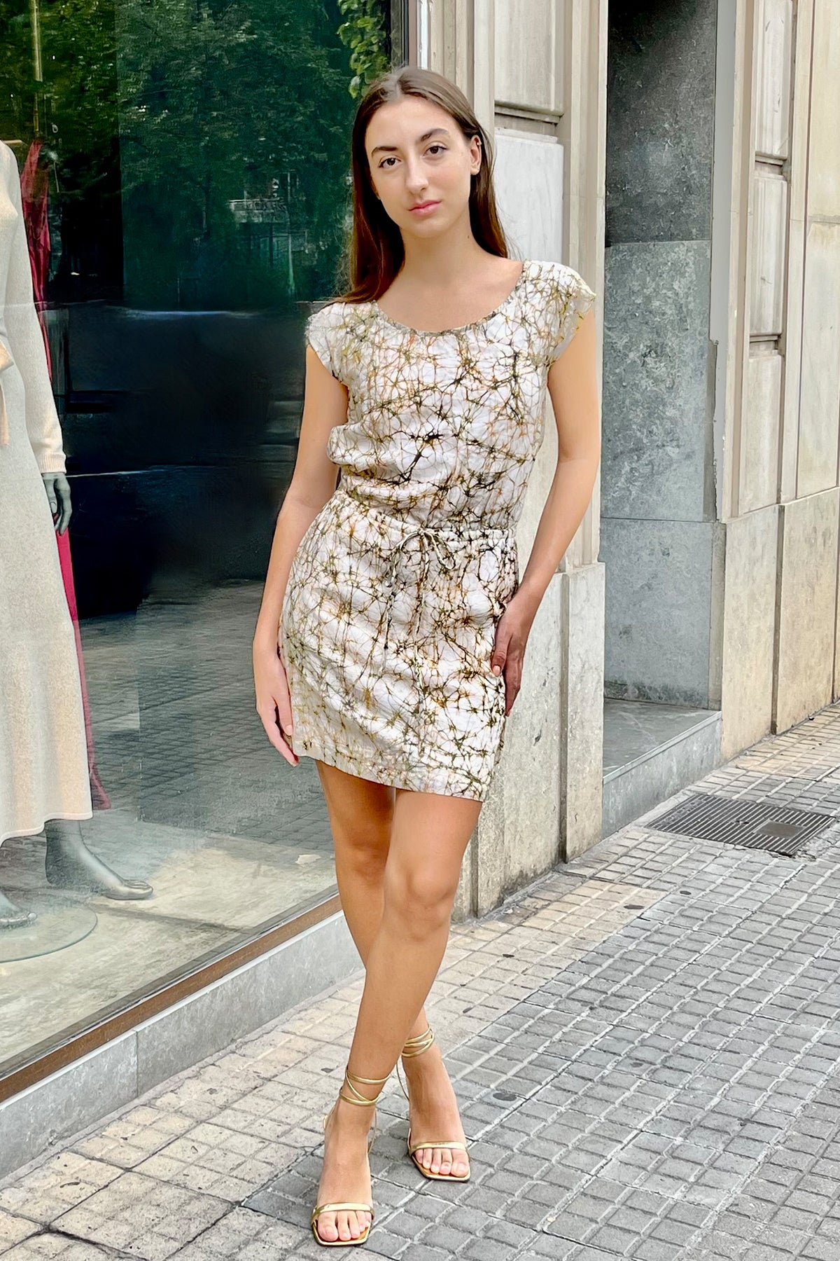 Modelo posando de frente con vestido corto Wren en tonos tierra, mostrando su diseño elegante y corte moderno