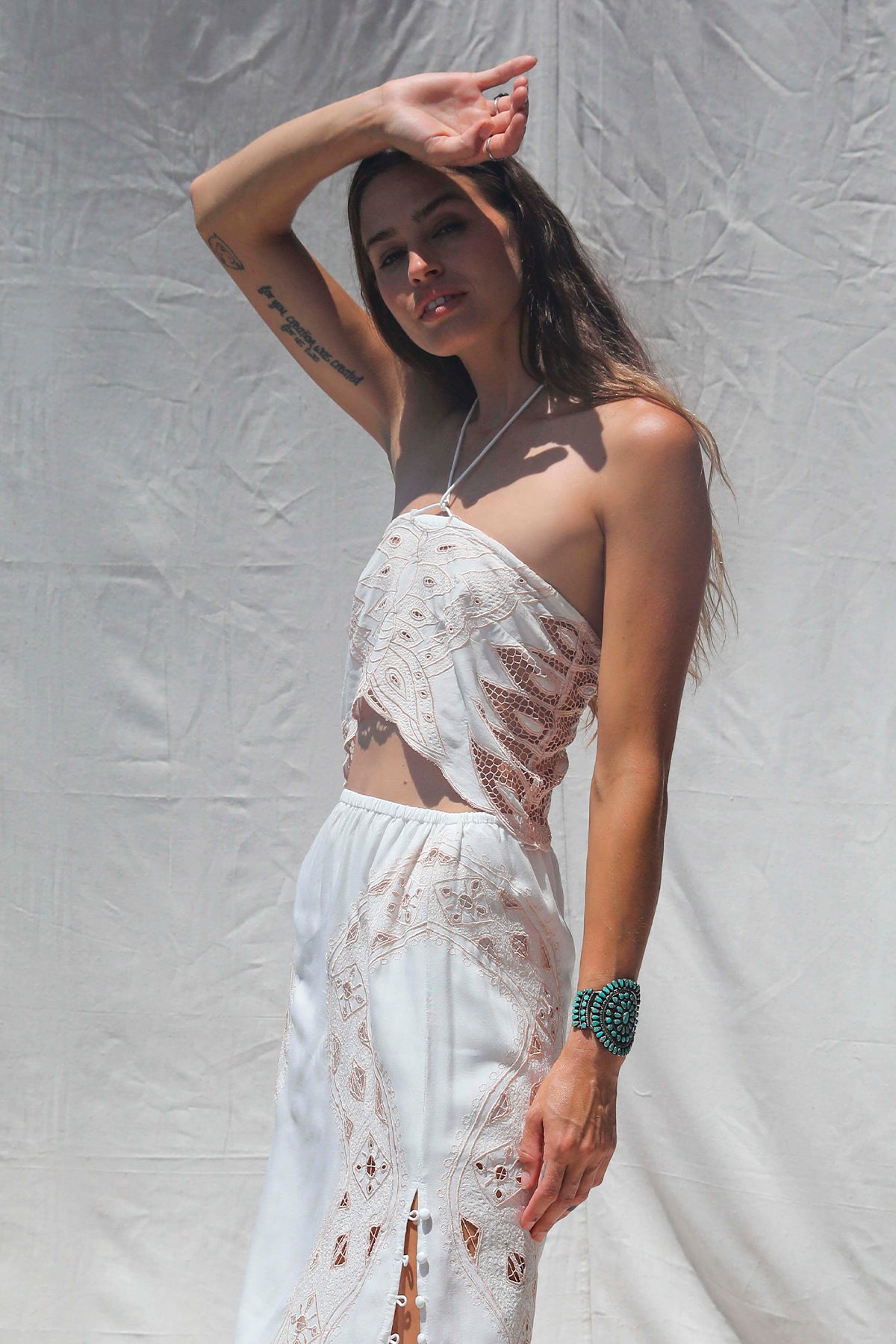 Modelo de frente con Dolly Crop Top color Western Bone con bordado de mariposa y tirante halter ajustable para estilo boho festival