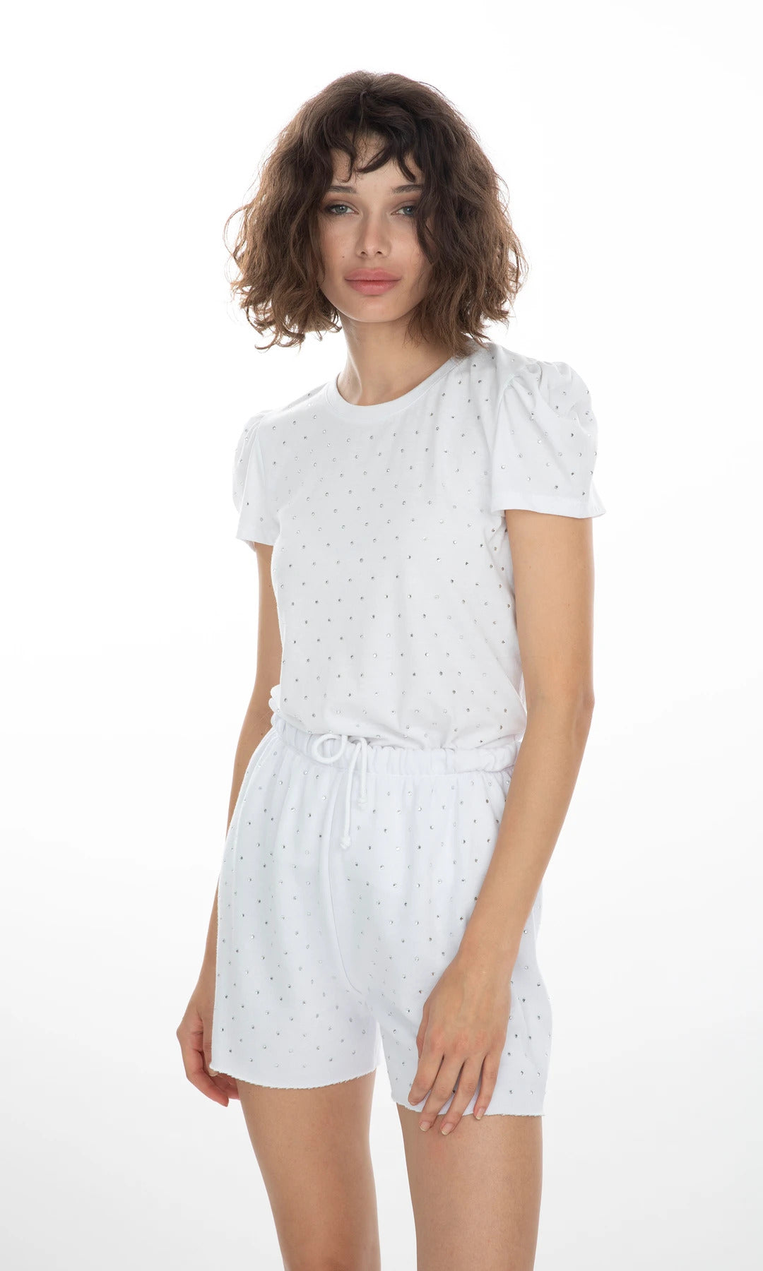 Shorts Aria Crystal blancos con pedrería, modelo de frente en pose relajada, estilo femenino y sofisticado