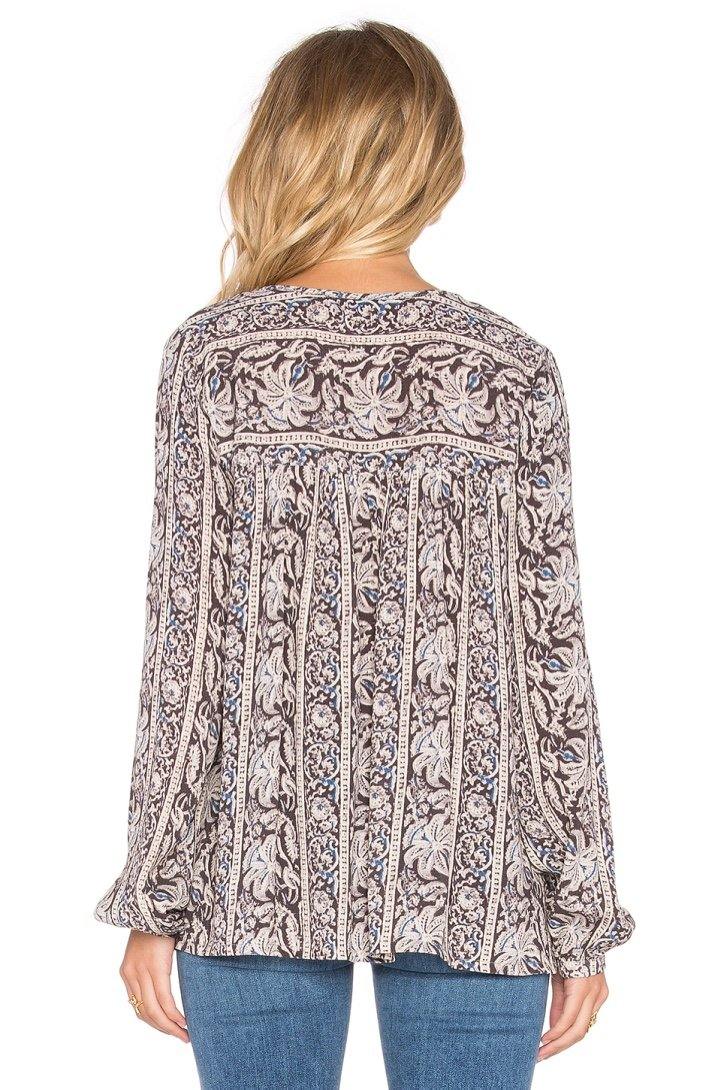 Imagen trasera de modelo con blusa negra Sunset Meadow, mostrando lazo ajustable y diseño elegante en fondo blanco limpio y minimalista