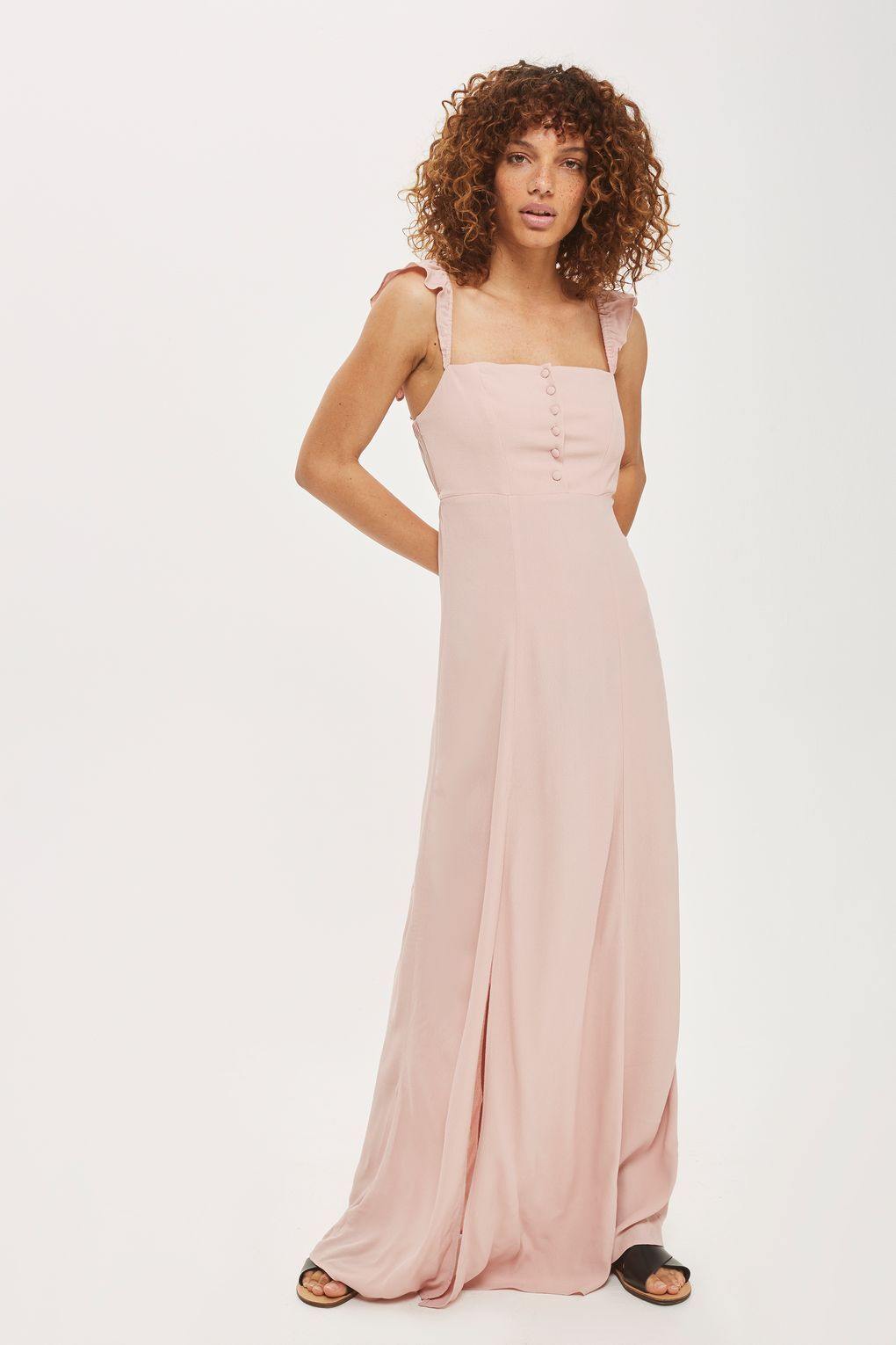 Modelo con vestido Bardot Sweet Cherry Pie rosa, escote recto y volantes Bardot sobre fondo blanco