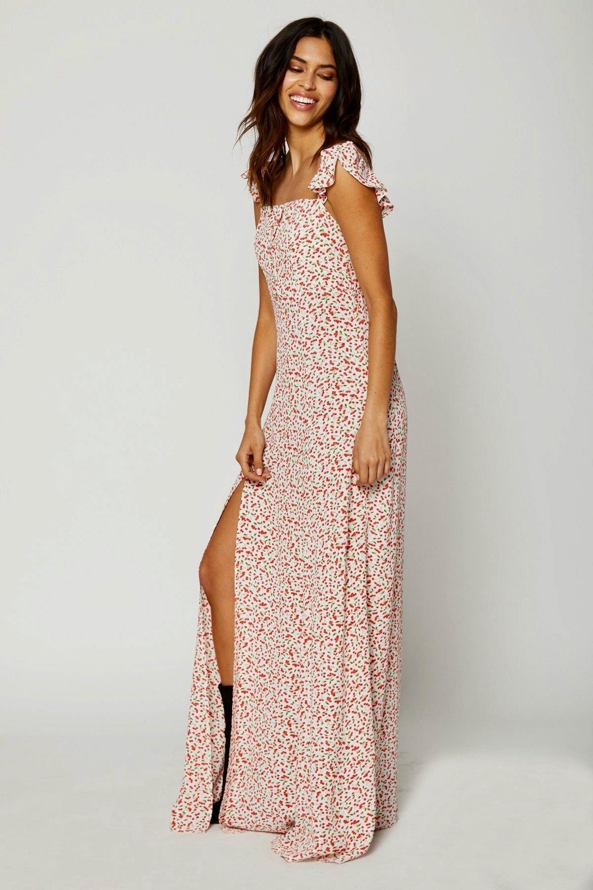 Modelo en pose girada frente-fondo neutro con vestido largo Bardot rosa, destacando etiqueta oversize