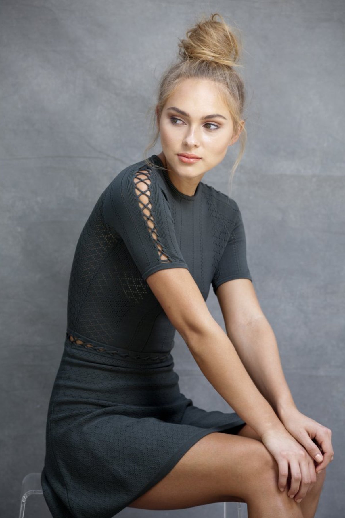 Modelo sentada de perfil con vestido Alexa Fit and Flare mostrando elegancia y comodidad en postura relajada