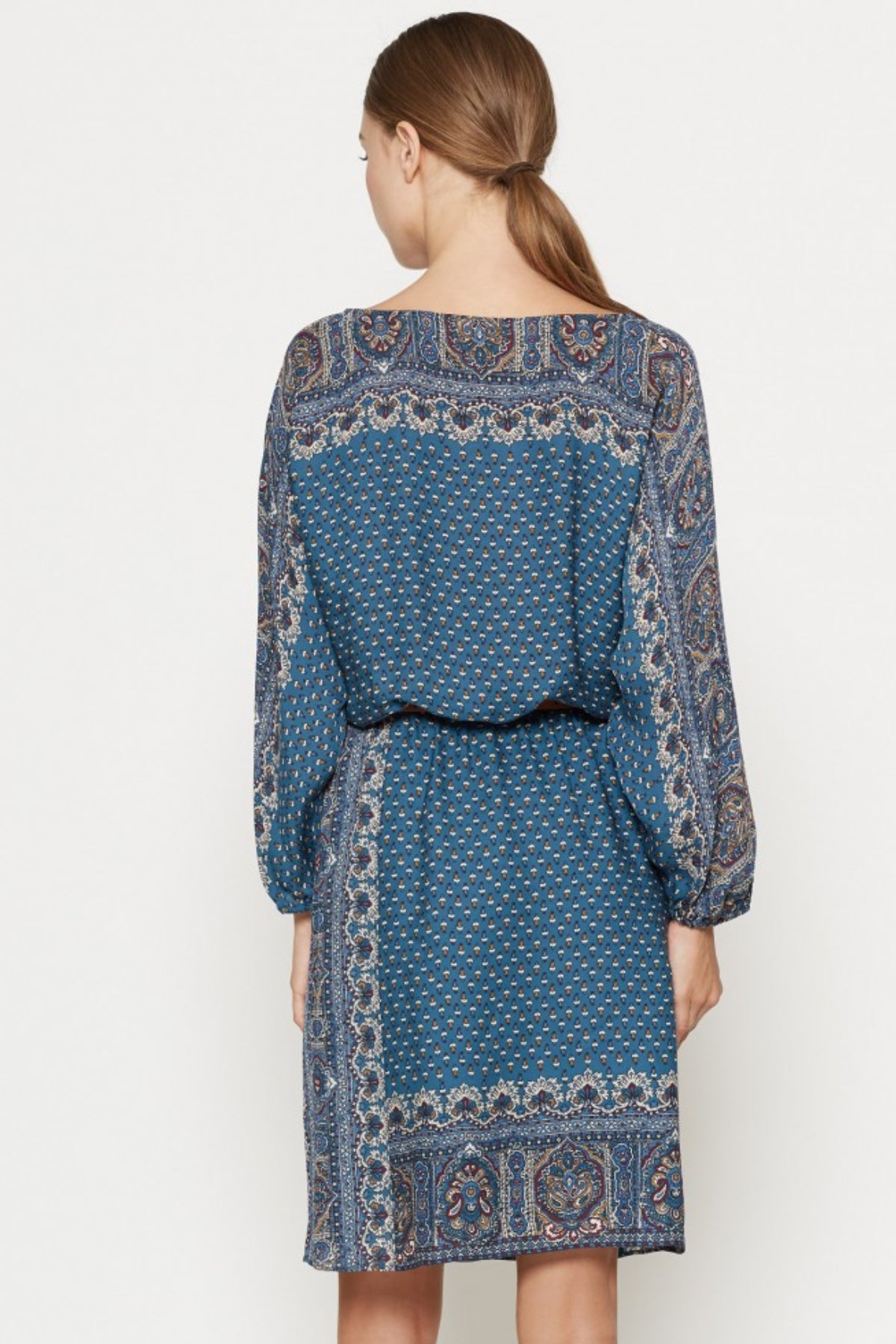 Modelo con el vestido corto Joie Emory sobre fondo negro mostrando la parte trasera del vestido y detalle de la caída elegante del tejido