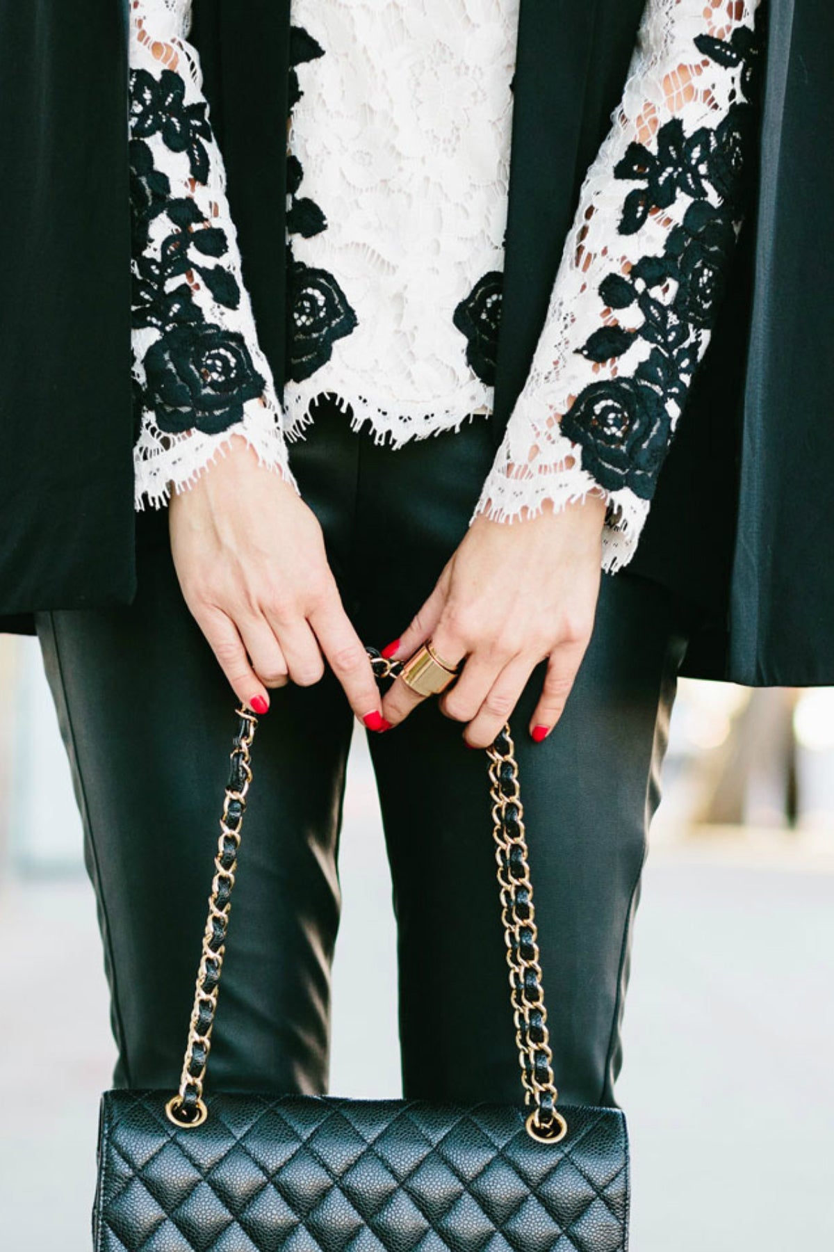 Detalle inferior del top Saylor Hannah con encaje floral negro, bordado en ondas y acabado delicado en la cintura