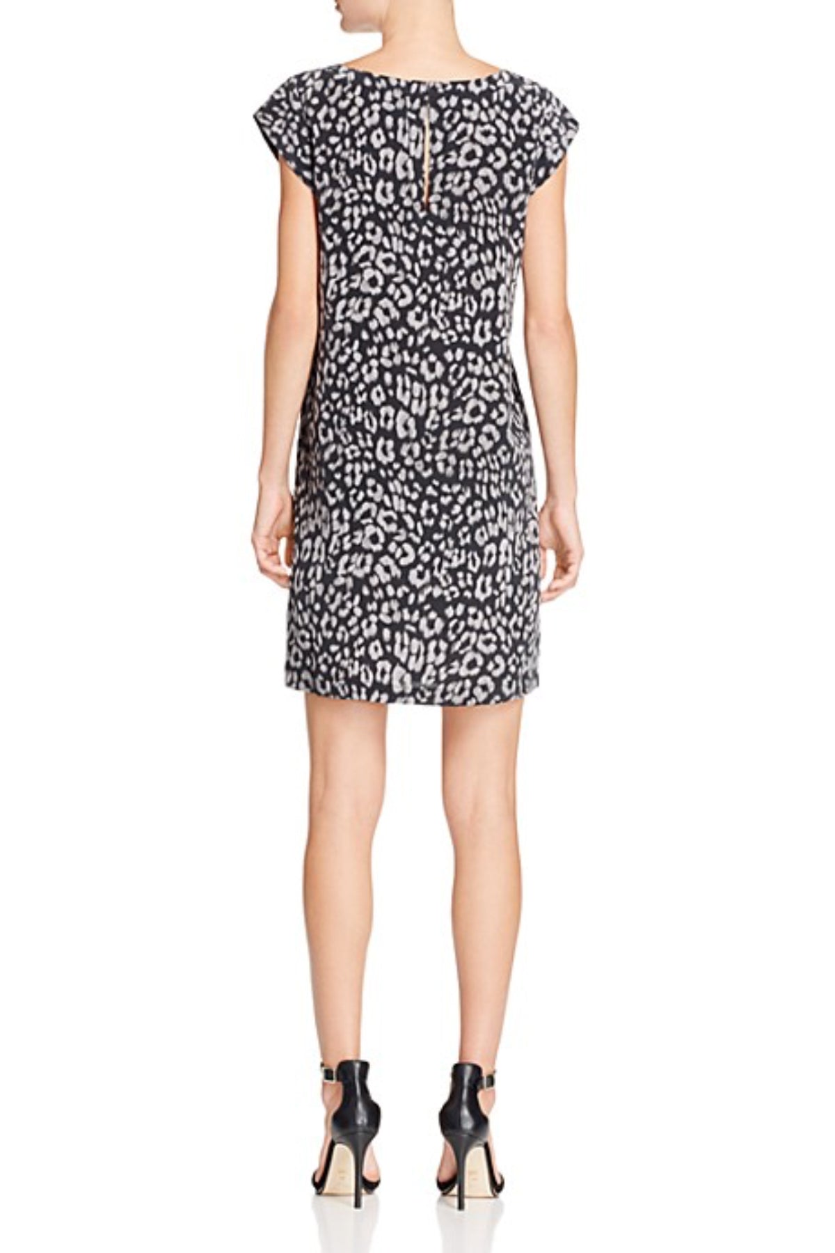 Plano trasero de la modelo con vestido Joie Weaver de seda natural sobre fondo blanco resaltando la caída y ajuste perfecto