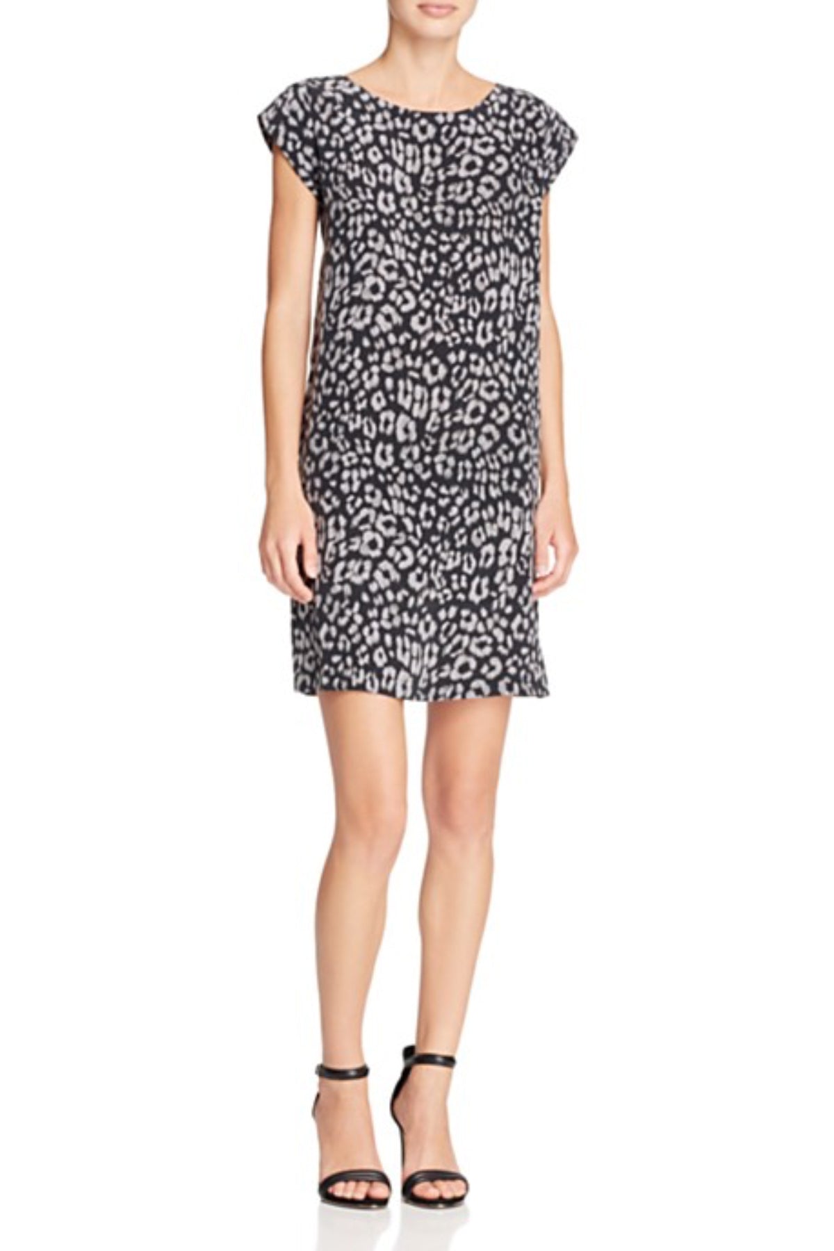 Modelo posando con el vestido corto Joie Weaver de seda marfil sobre fondo blanco mostrando un estilo elegante y sofisticado