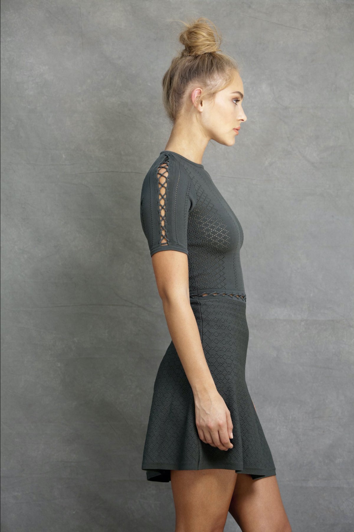 Vista lateral del vestido Alexa mini Fit and Flare oliva en modelo realzando el diseño entallado y la falda con volumen natural