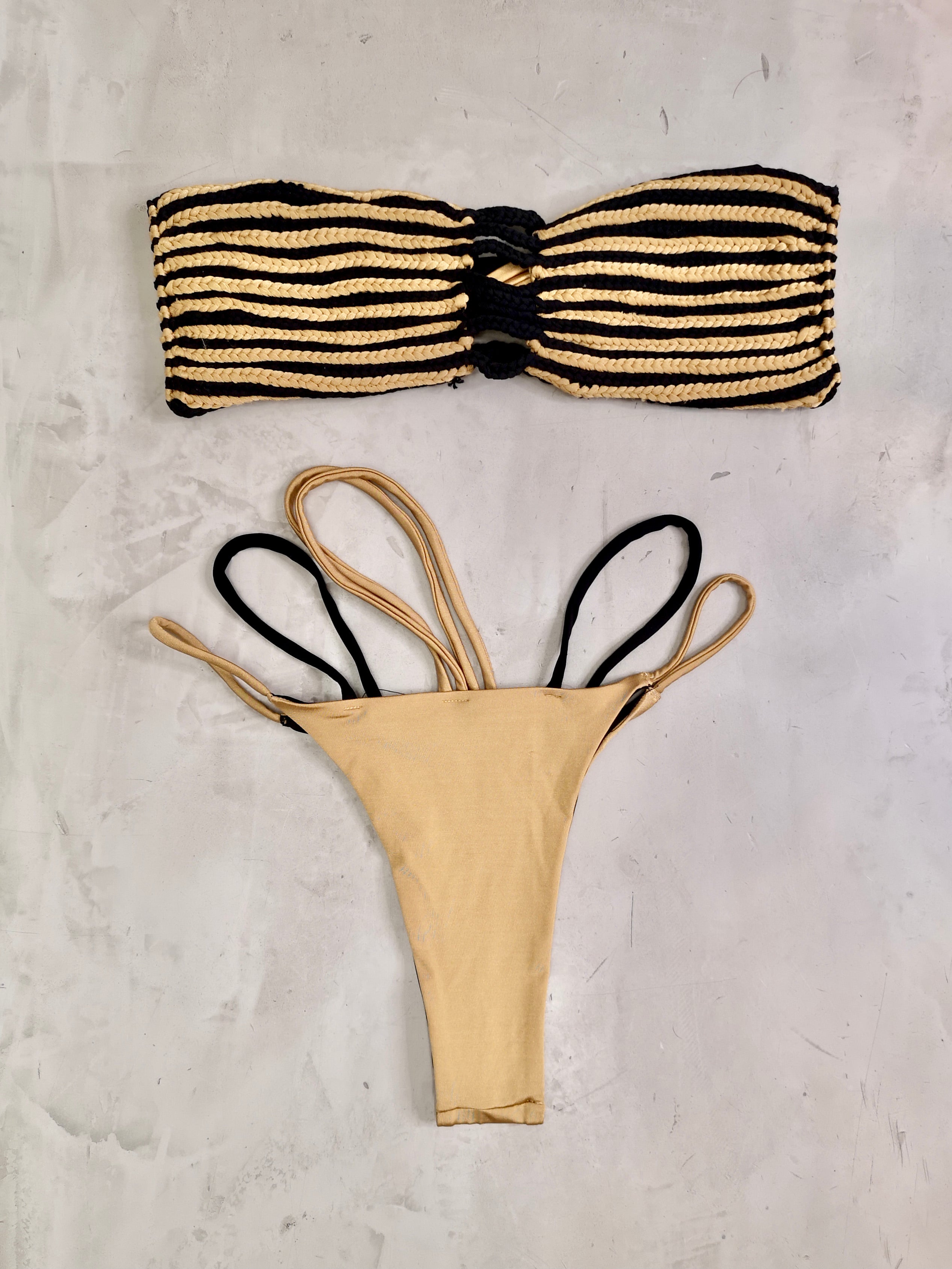 Vista delantera del bikini Charmosa Bella Gold Black sobre fondo blanco, top trenzado artesanal y braguita reversible elegante