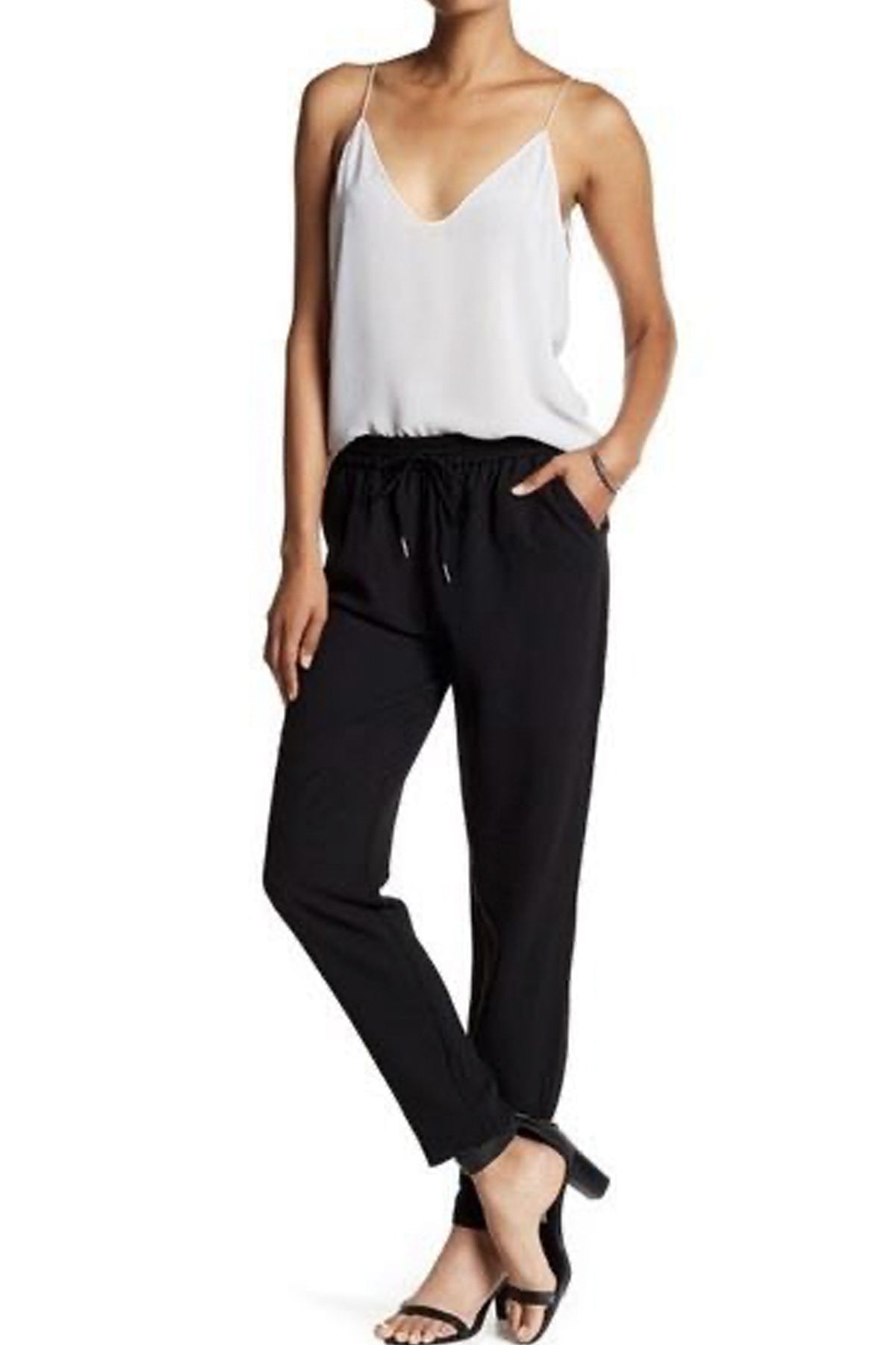 Modelo posando sobre fondo blanco con los pantalones Joie Janeene en negro, destacando el cordón ajustable, corte tobillero y estilo moderno y elegante