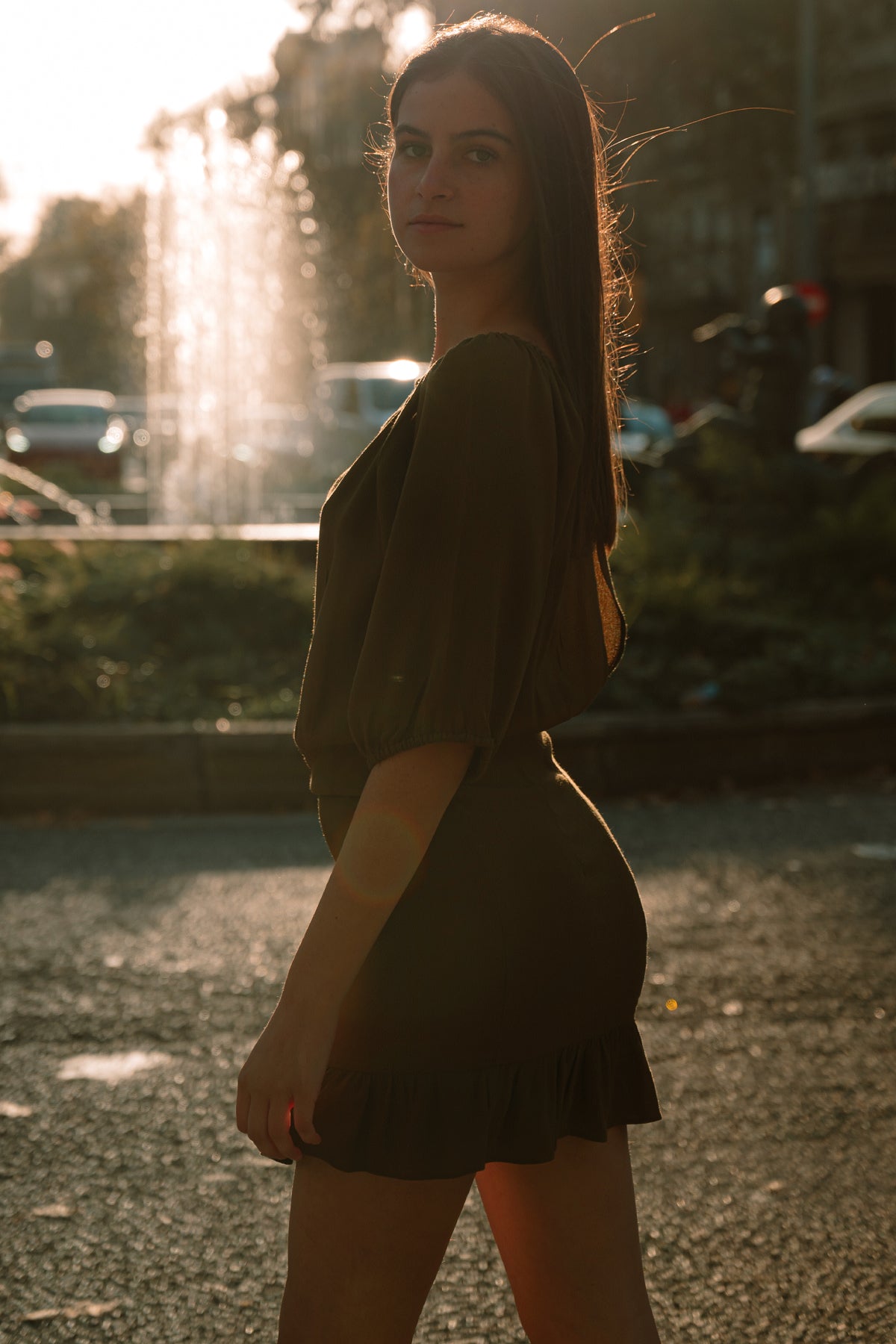 Vista de perfil del vestido Flynn Skye Kristina oliva, destacando falda con volantes, cintura ajustada y manga ¾ con puño elástico