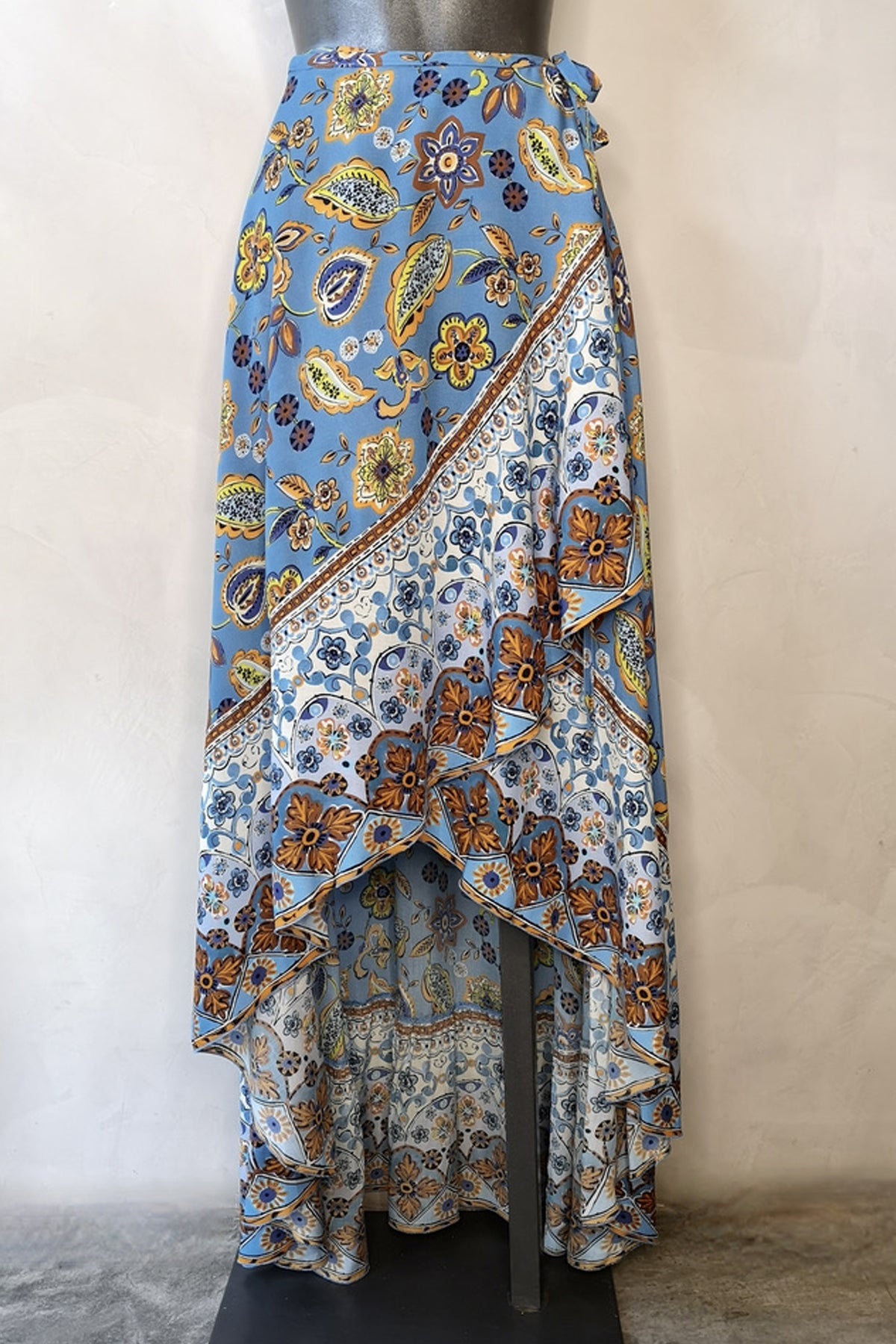 Falda larga boho de Raffaela D'Angelo con volantes, diseño envolvente y talle alto en viscosa azul paisley, vista trasera en maniquí