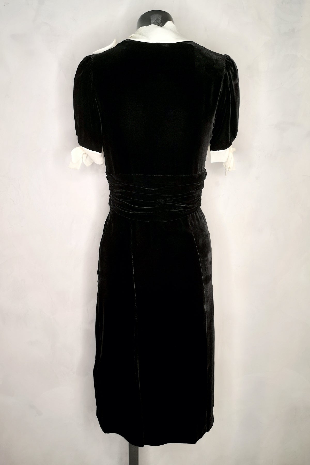 Vista trasera del vestido midi de terciopelo Luisa Beccaria en color burdeos, mostrando el corte y detalles en un maniquí sobre fondo blanco