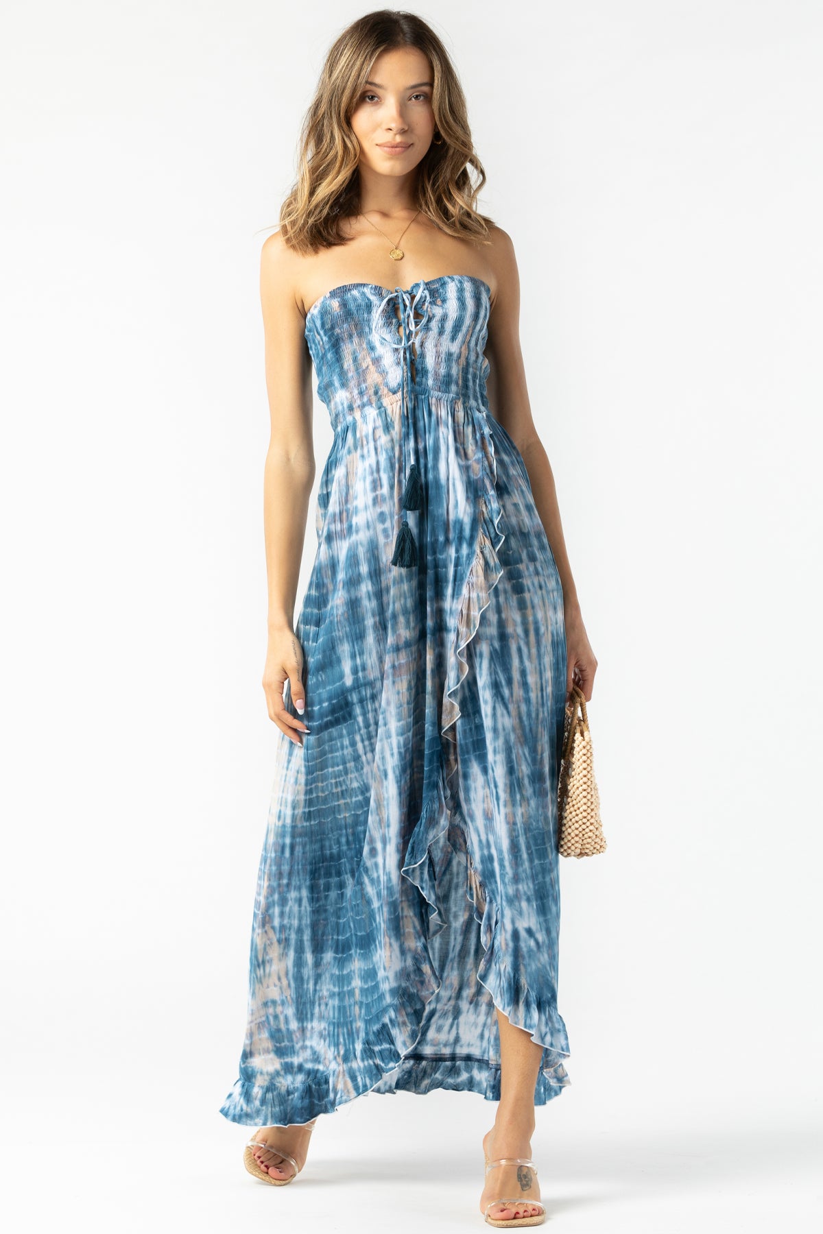 Modelo frontal con Flynn maxi Tie Dye navy‑stone‑white en ambiente natural, escote strapless y caída vaporosa
