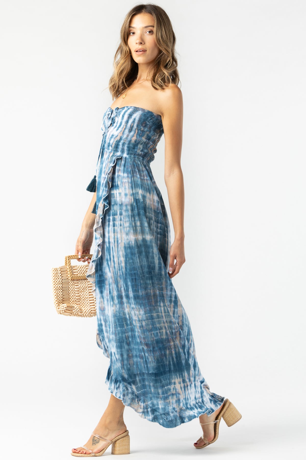 Vista lateral del Flynn maxi navy‑stone‑white mostrando silueta cruzada y estampado degradado elegantemente fluido