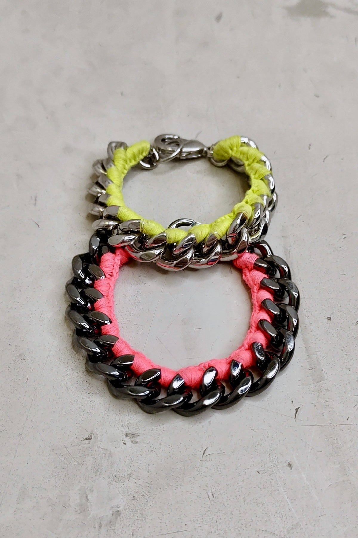 Pulseras en neón rosa y amarillo combinadas sobre fondo blanco, destacando sus colores intensos y acabado brillante para un look llamativo
