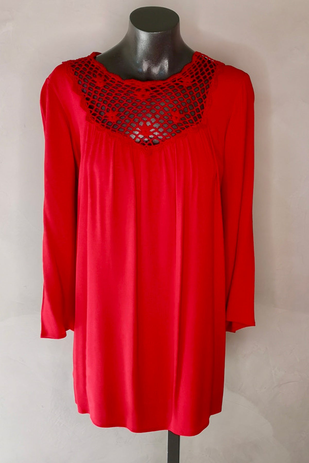 Primer plano del detalle de crochet floral en mangas del vestido rojo Eternal Sunshine, resaltando textura y diseño crepé