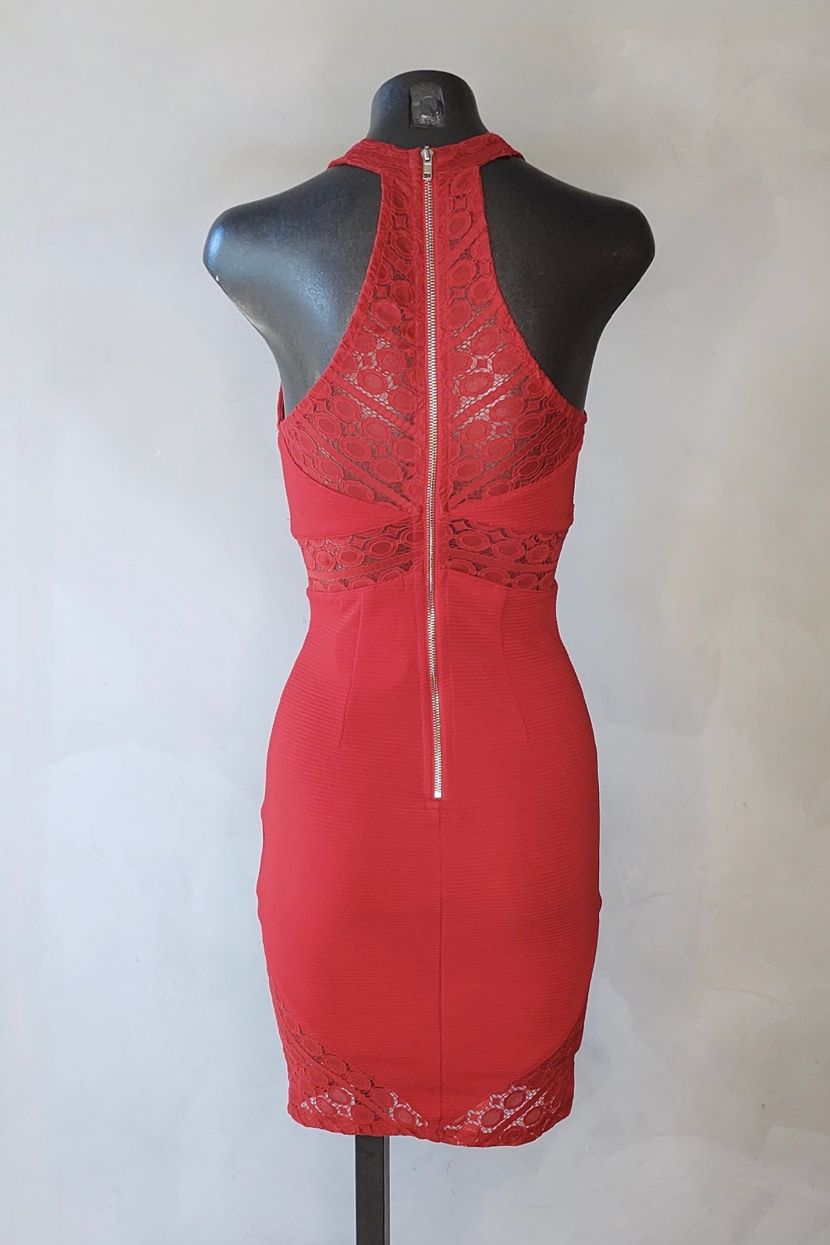 Vista trasera del minivestido rojo en maniquí destacando el diseño sin forro y caída elegante sobre fondo neutro