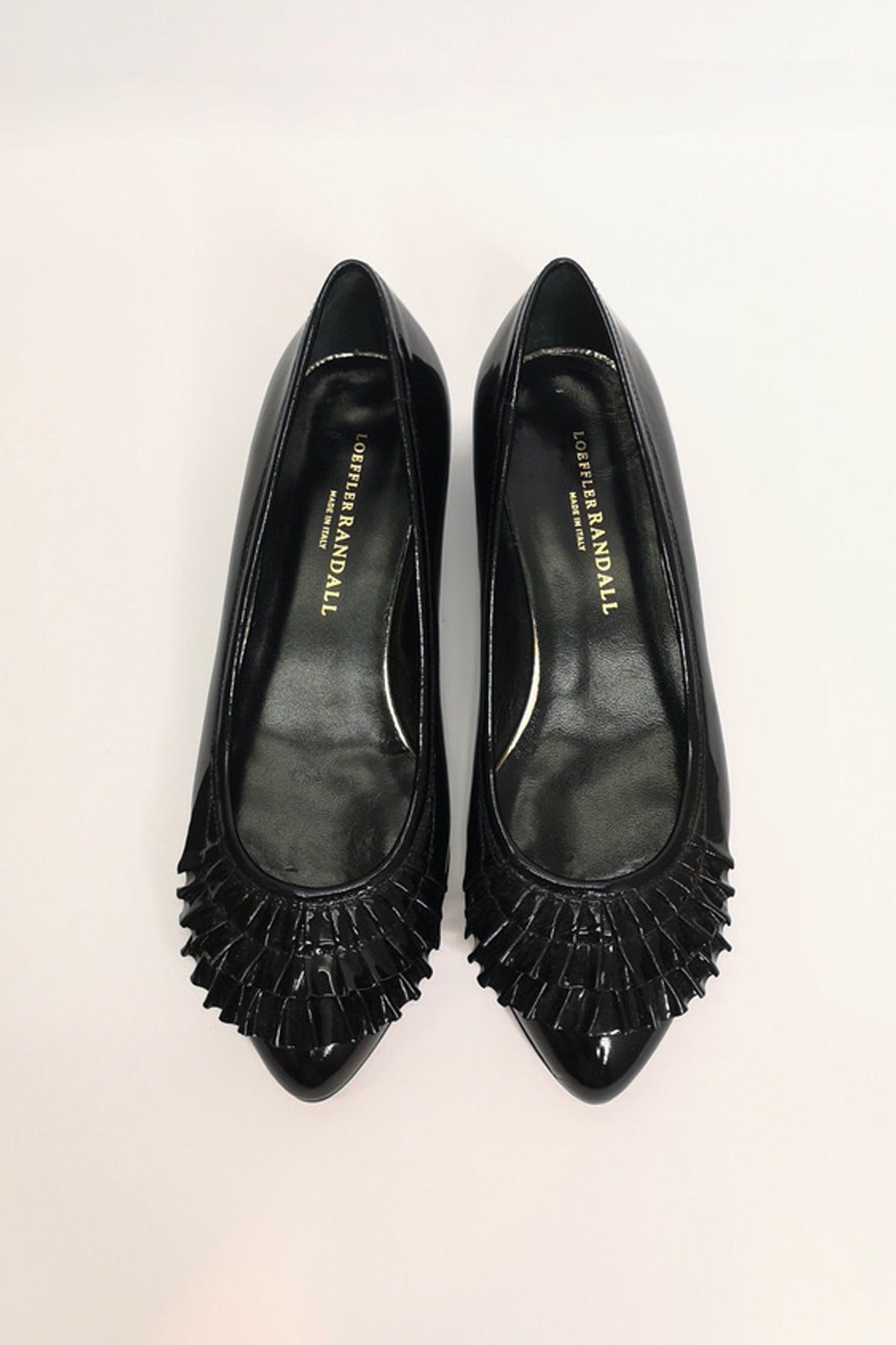 Zapatos planos Delphine en charol elegantemente presentados sobre fondo blanco para resaltar su diseño clásico y moderno